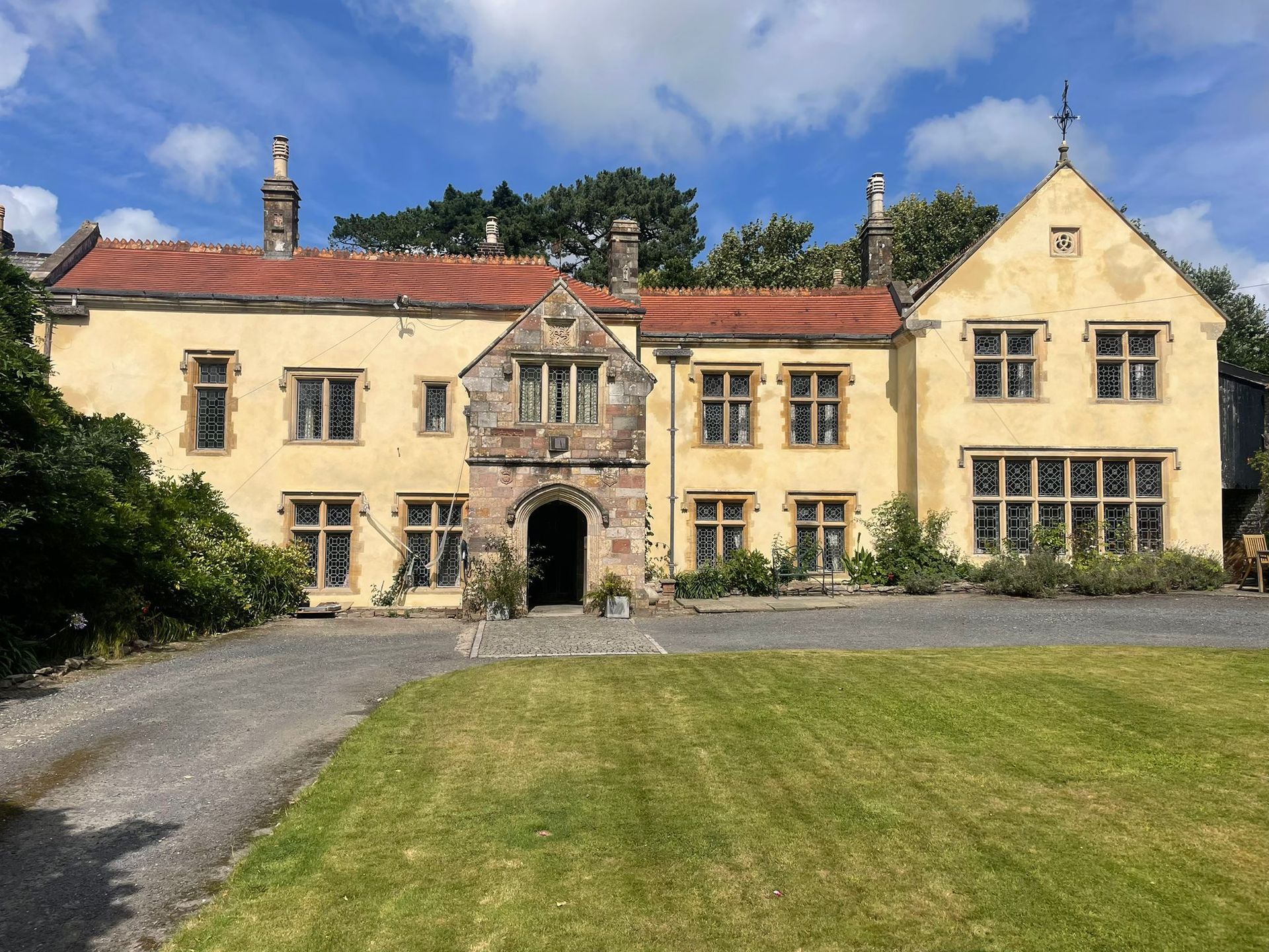 A headset is sitting on a desk next to a laptop and a phone.