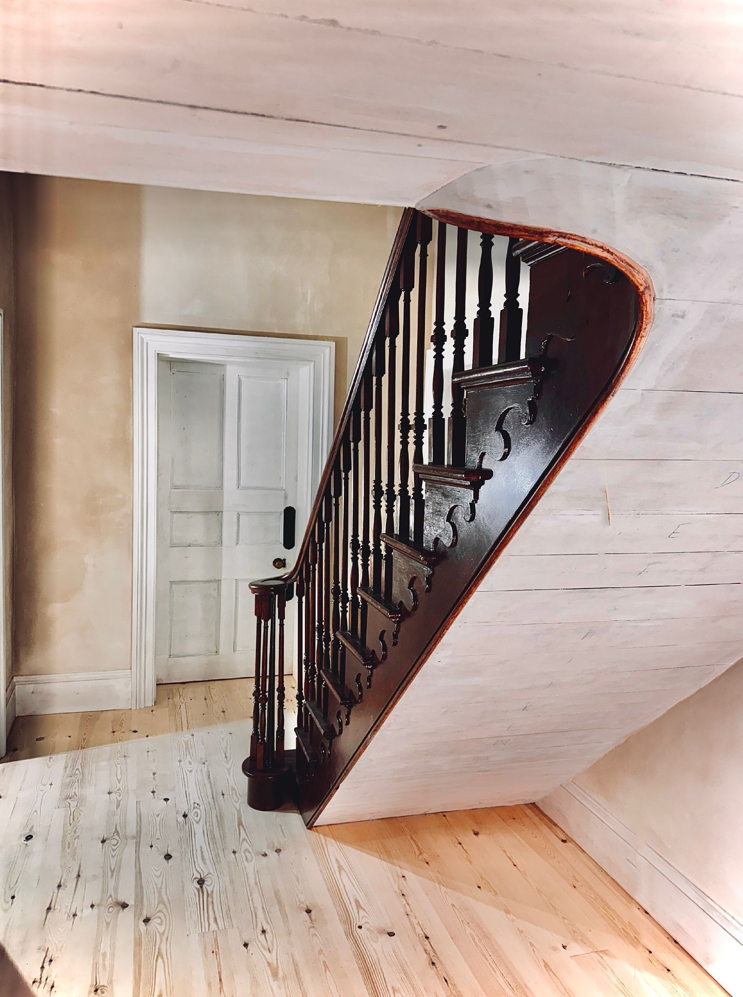 A staircase with a wooden floor and white walls