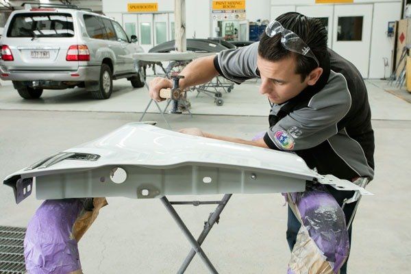 person looking at car part