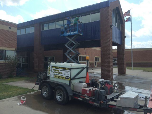 Men on a lifting platform cleaning a wall — Corsicana, TX — AKV Plumbing Co