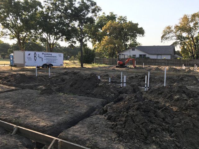 Installing pipe and excavator on a construction site — Corsicana, TX — AKV Plumbing Co