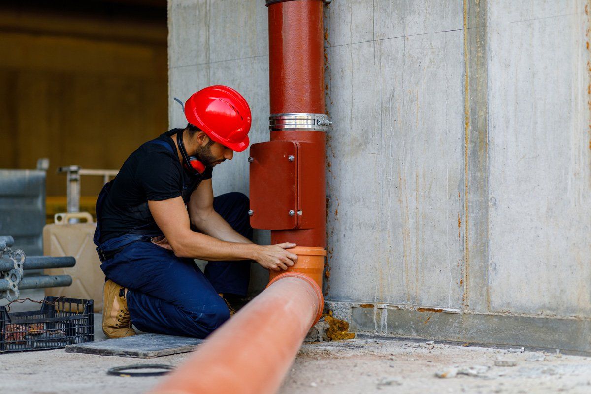 Plumber fixing a water pipe at a building site — Corsicana, TX — AKV Plumbing Co