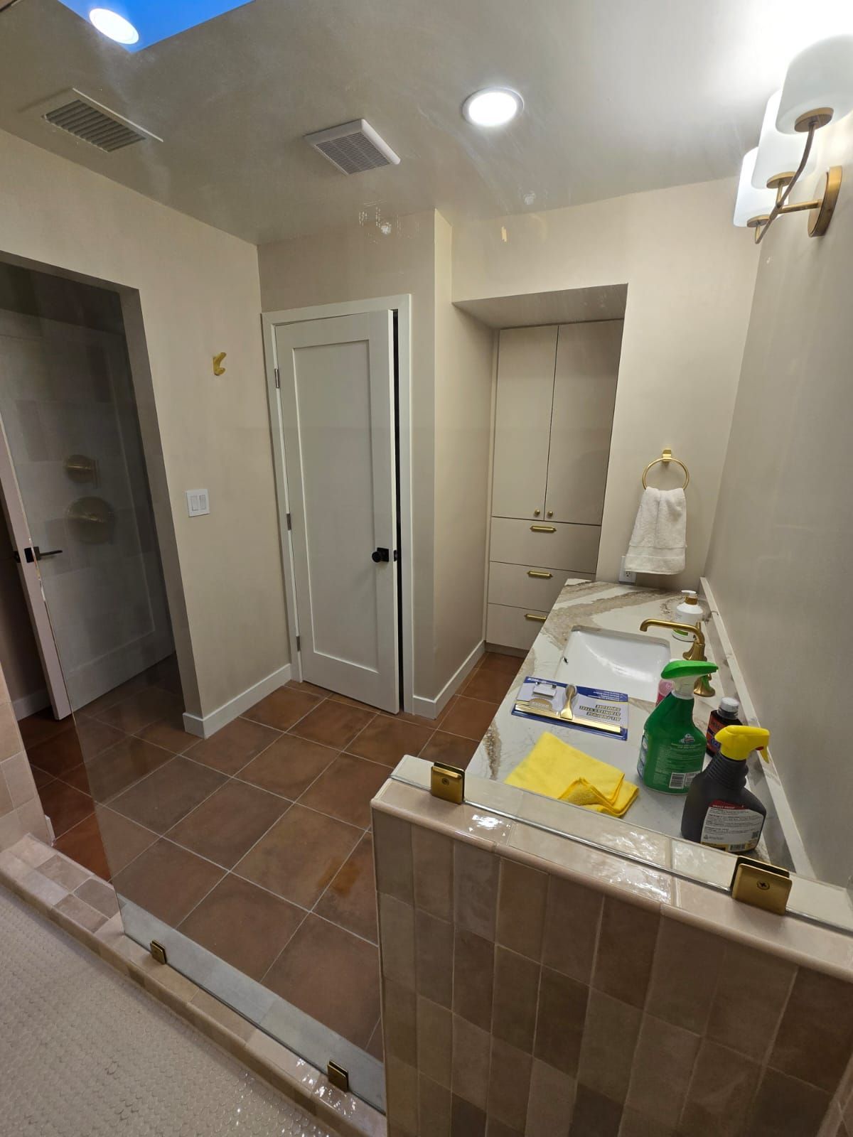 A bathroom with a sink , mirror , and skylight.