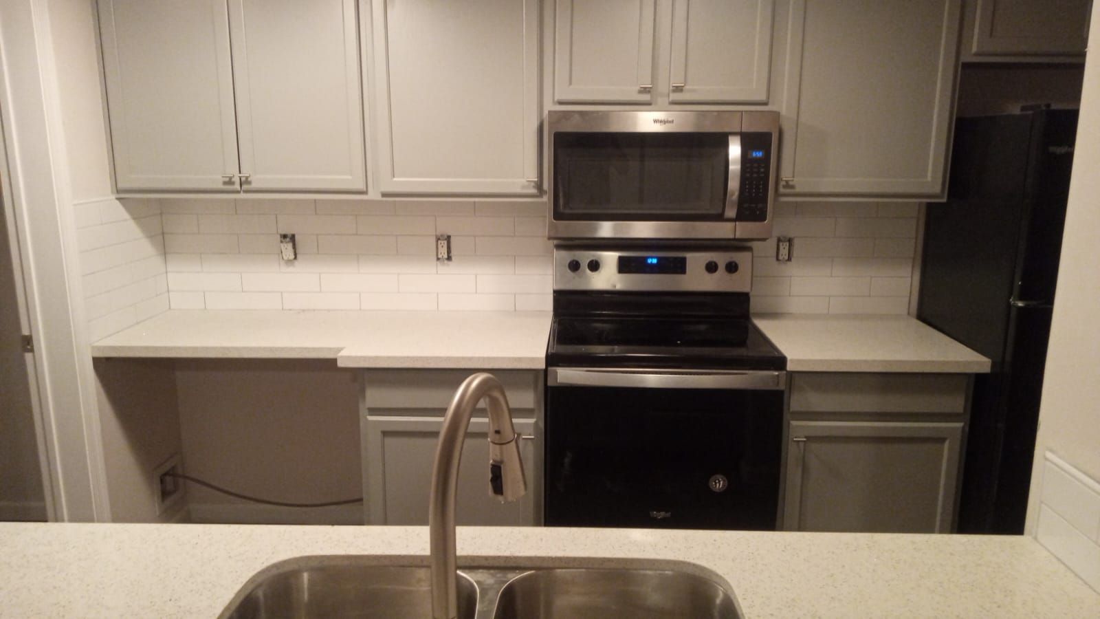 A kitchen with stainless steel appliances and white cabinets
