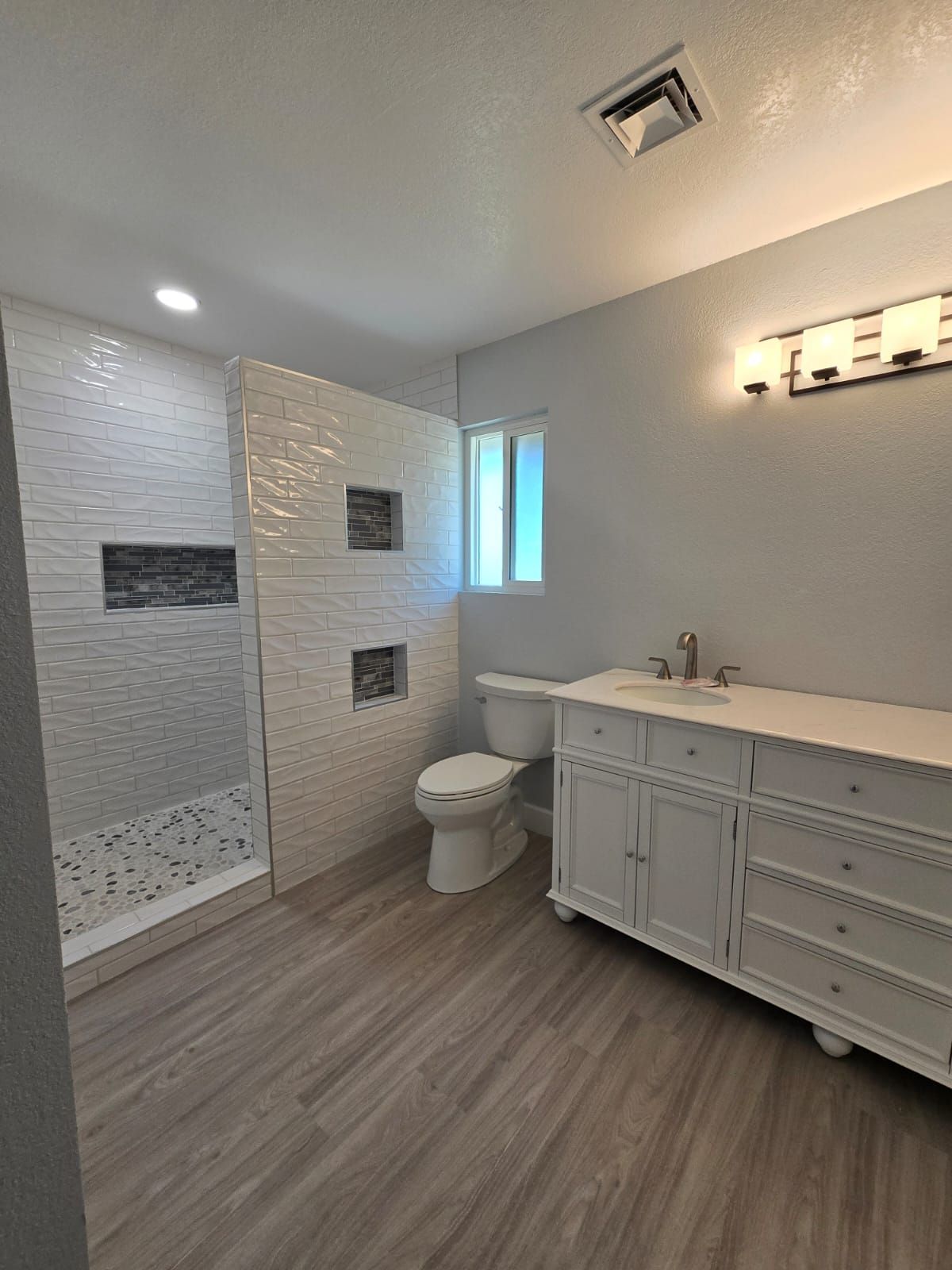 A bathroom with a toilet , sink , and shower.