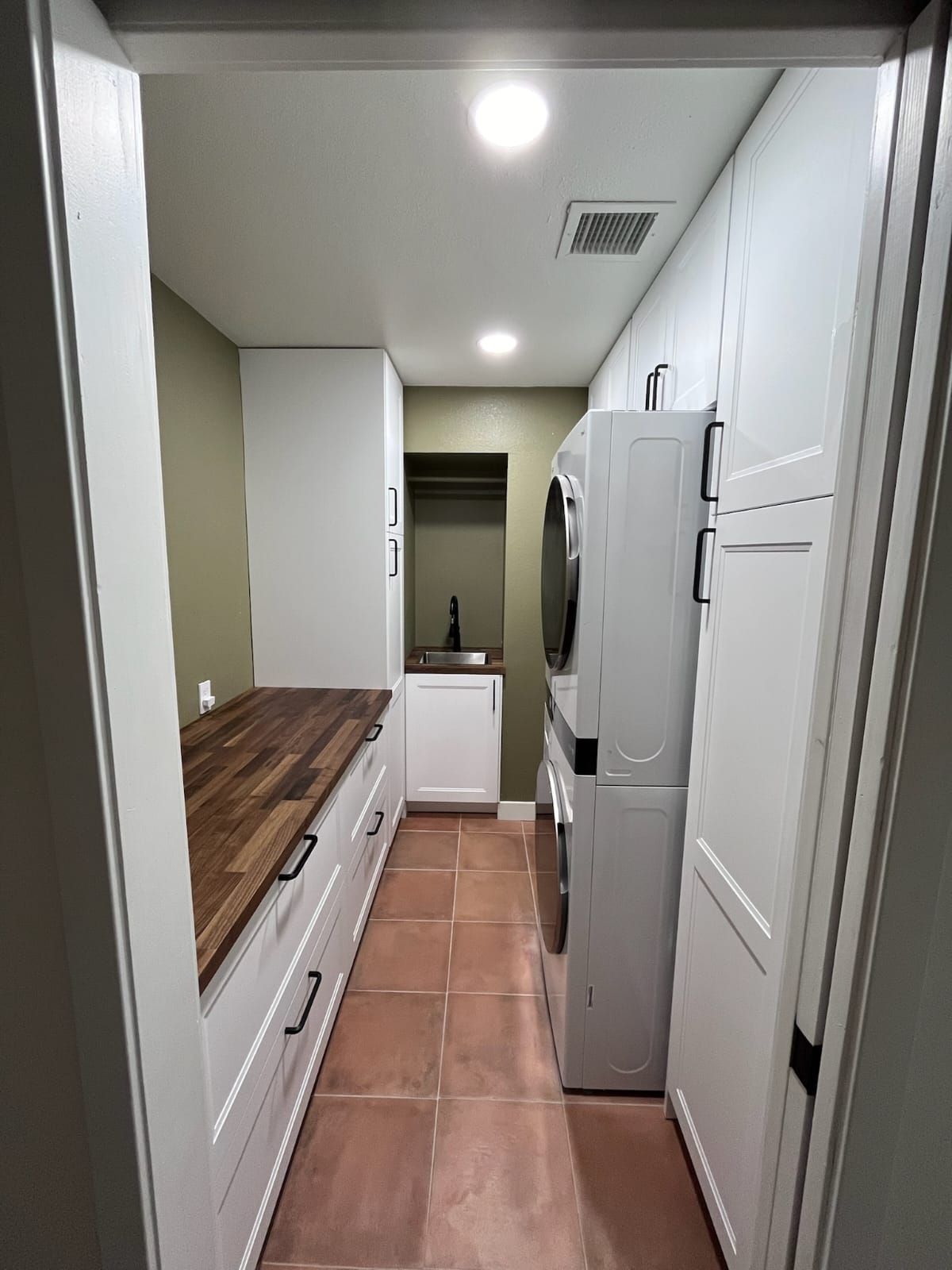 A laundry room with a washer and dryer stacked on top of each other.