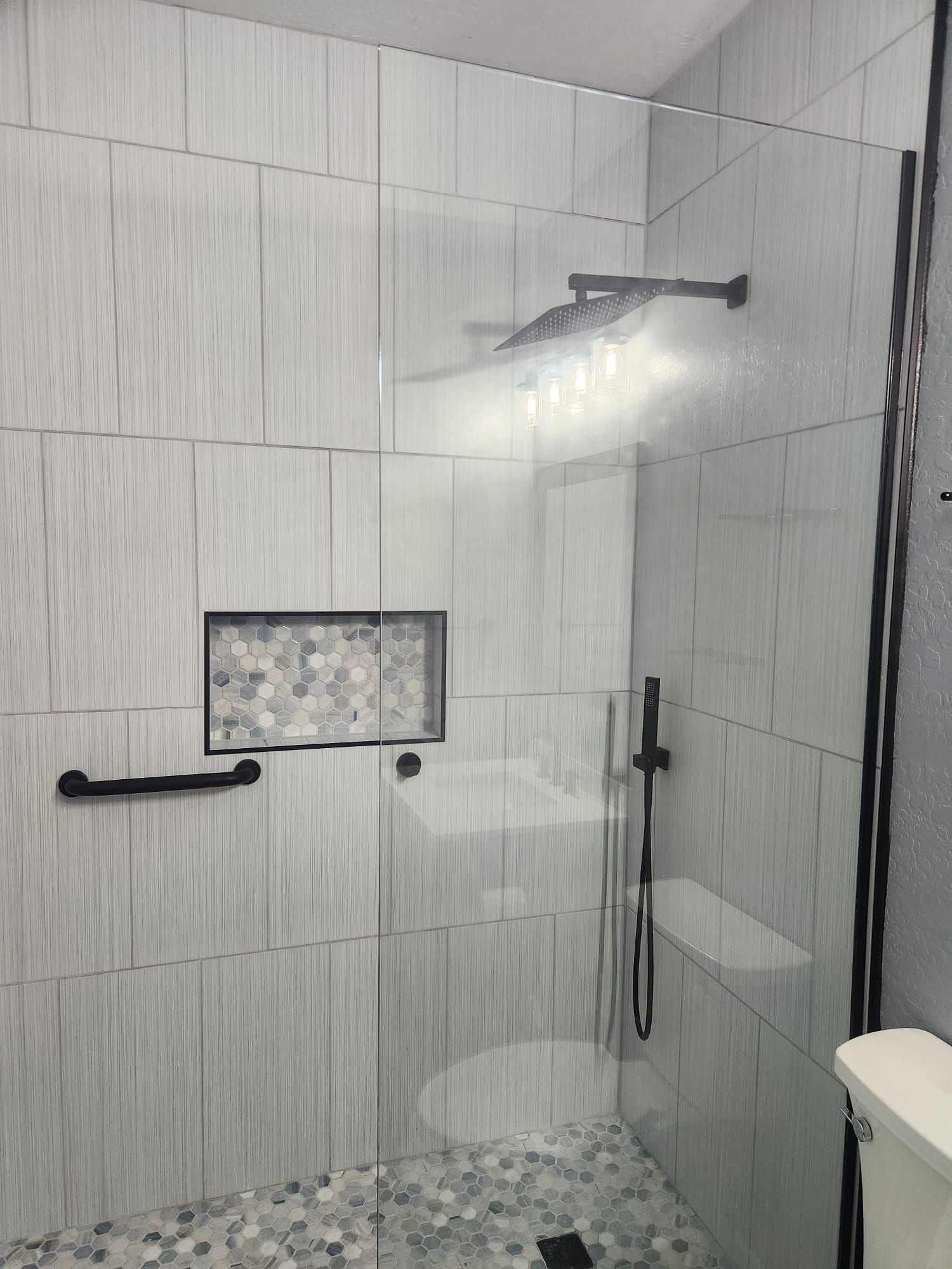 A bathroom with a walk in shower and a toilet.