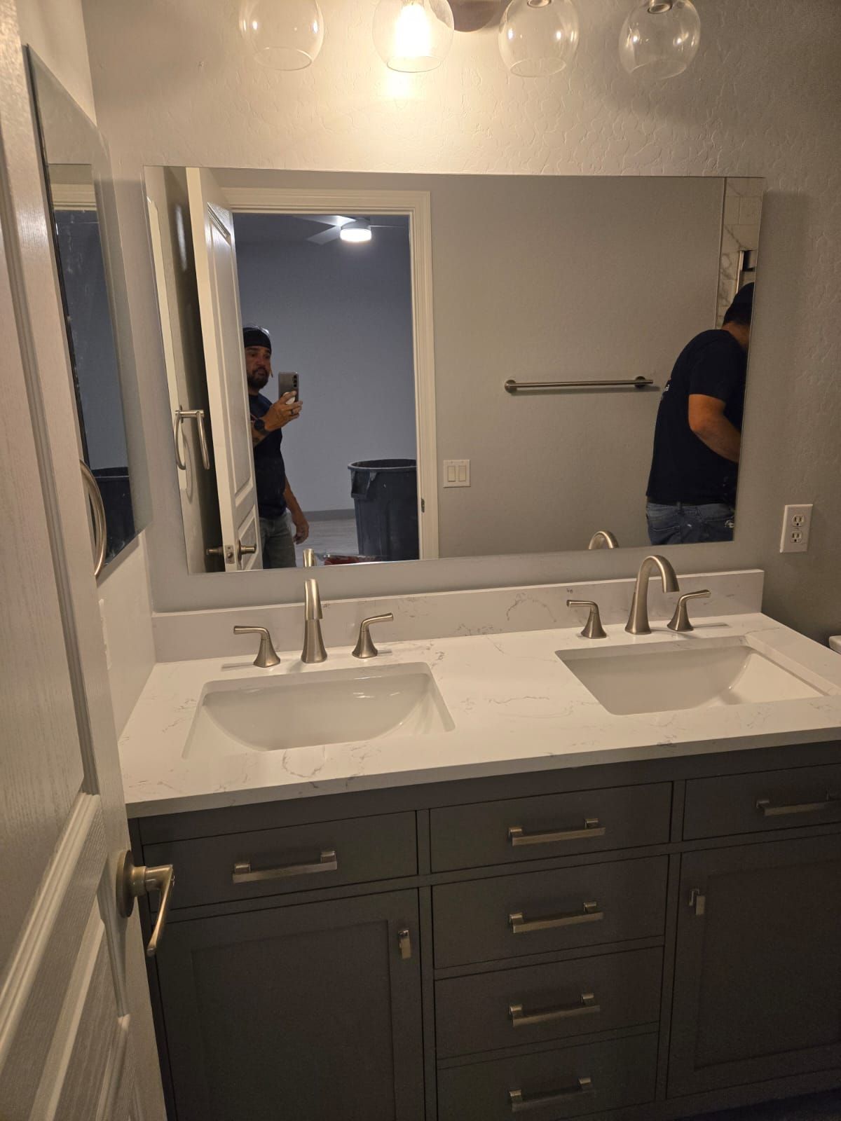 A bathroom with two sinks and a large mirror.