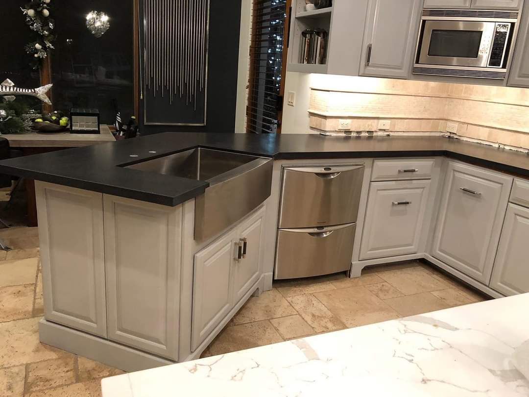 A kitchen with white cabinets and a stainless steel sink.