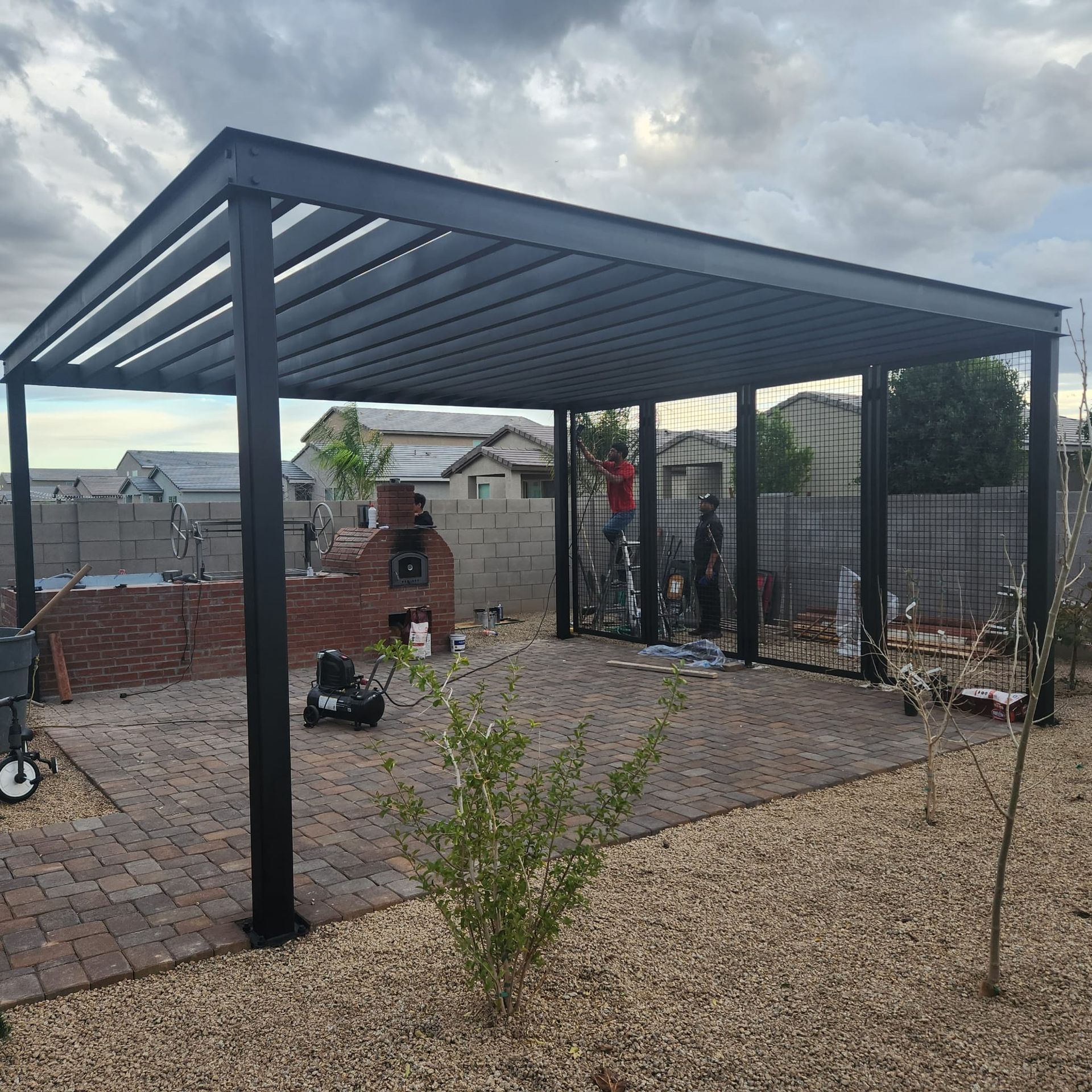 A black pergola is being built in a backyard