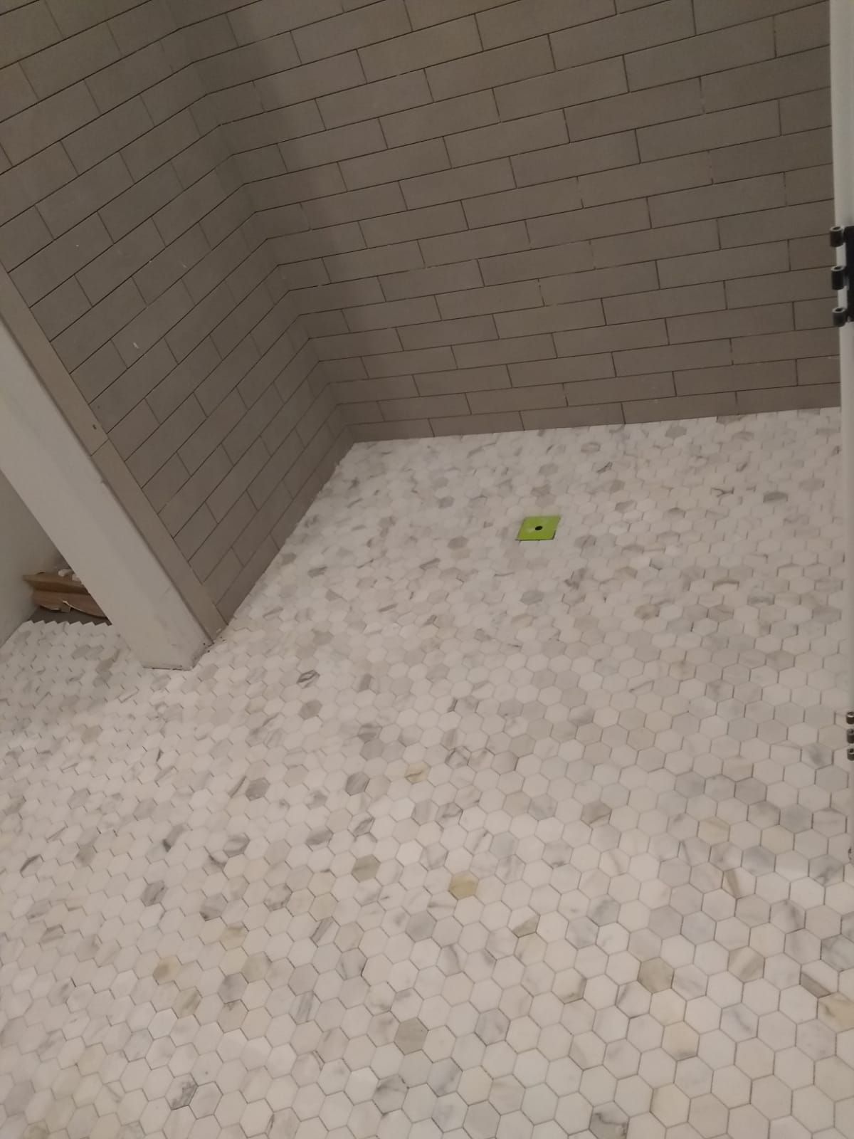 A bathroom with a shower stall and a tiled floor.