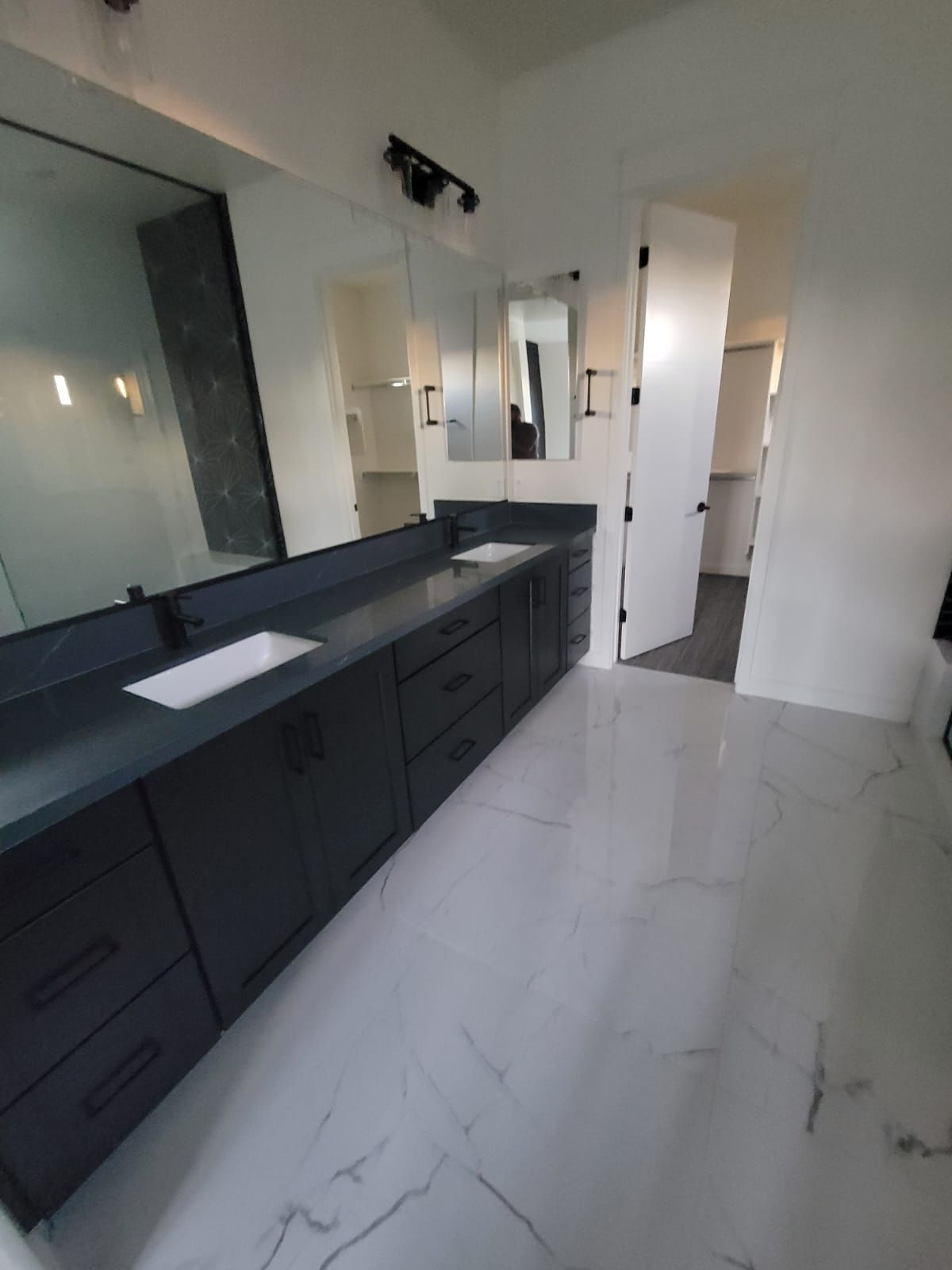 A bathroom with two sinks and a large mirror