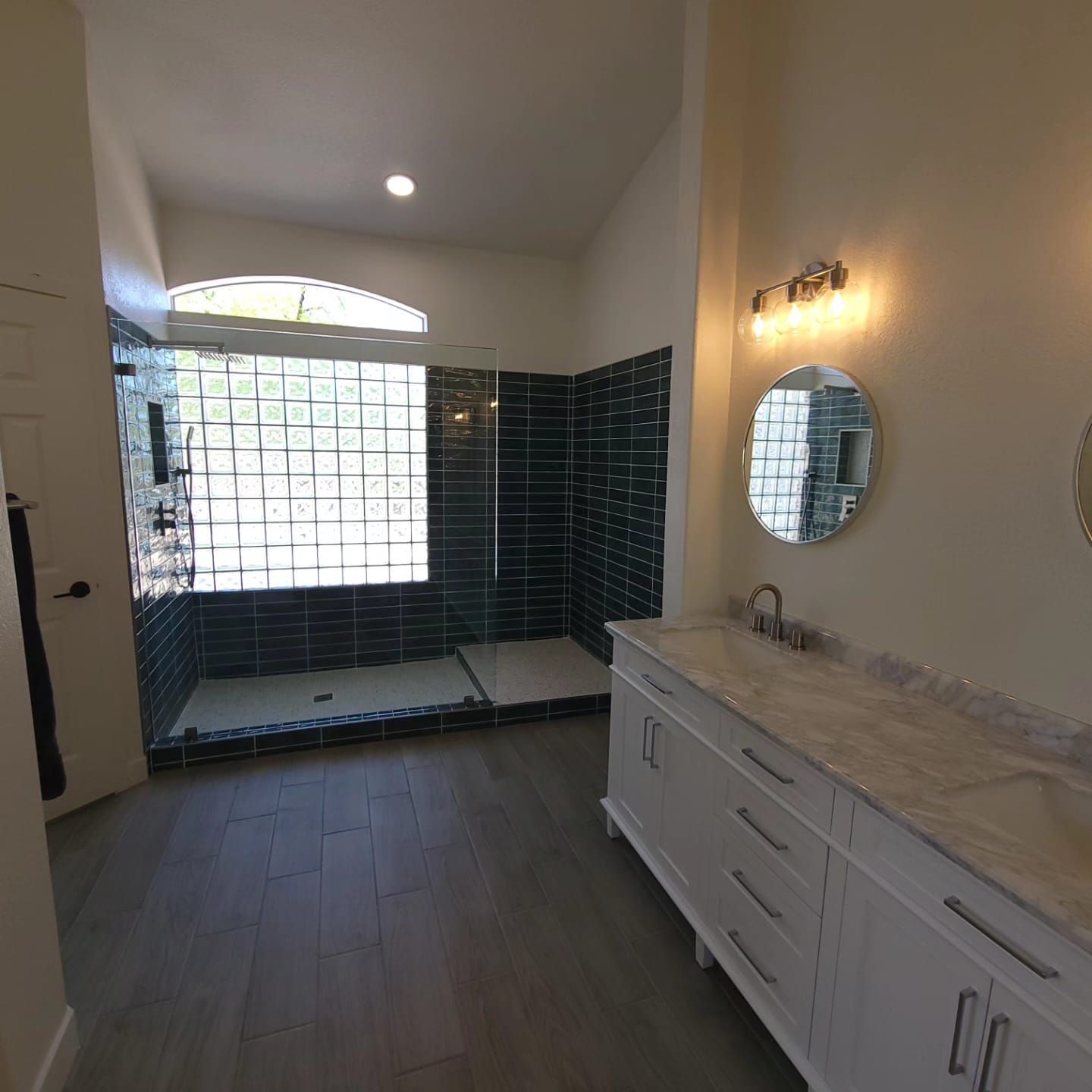 A bathroom with a sink , mirror and shower.