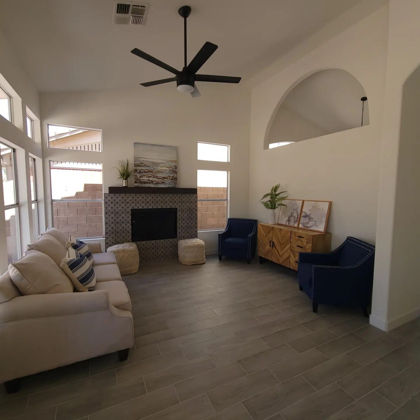 A living room with a fireplace and a ceiling fan