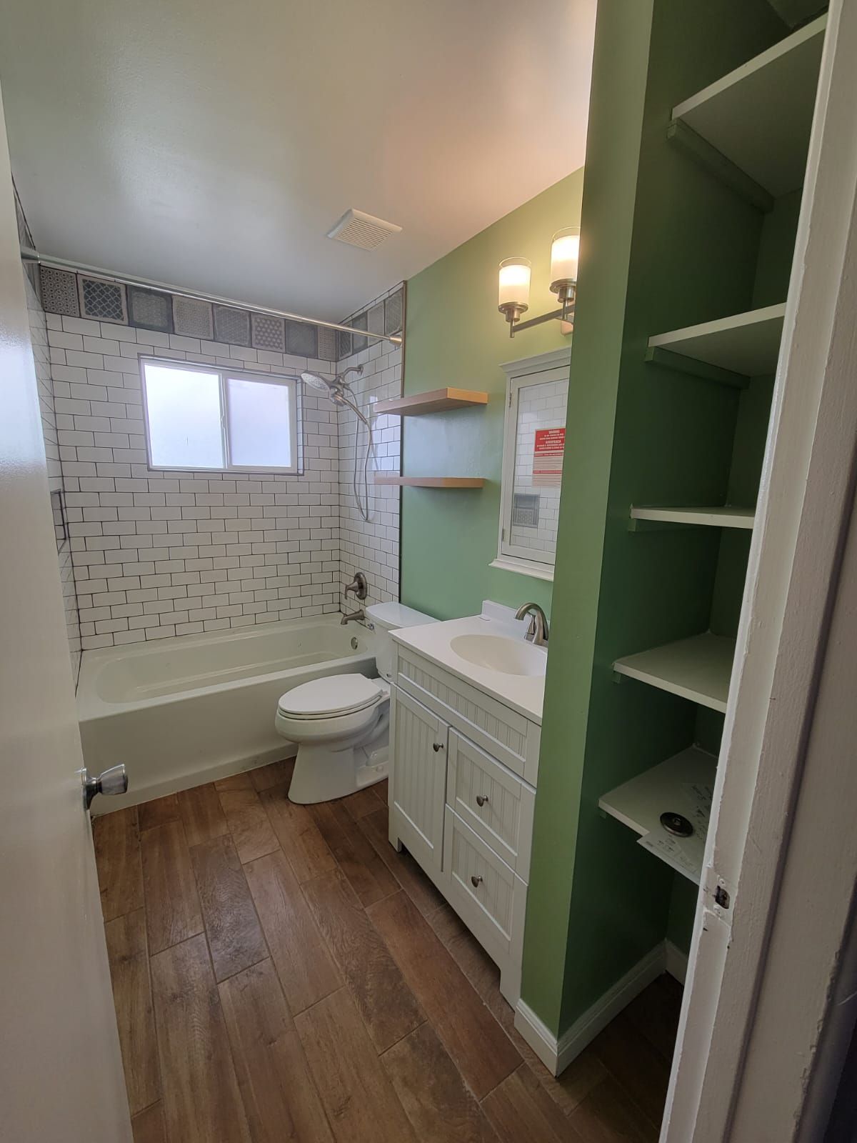 A bathroom with a toilet , sink , and bathtub.