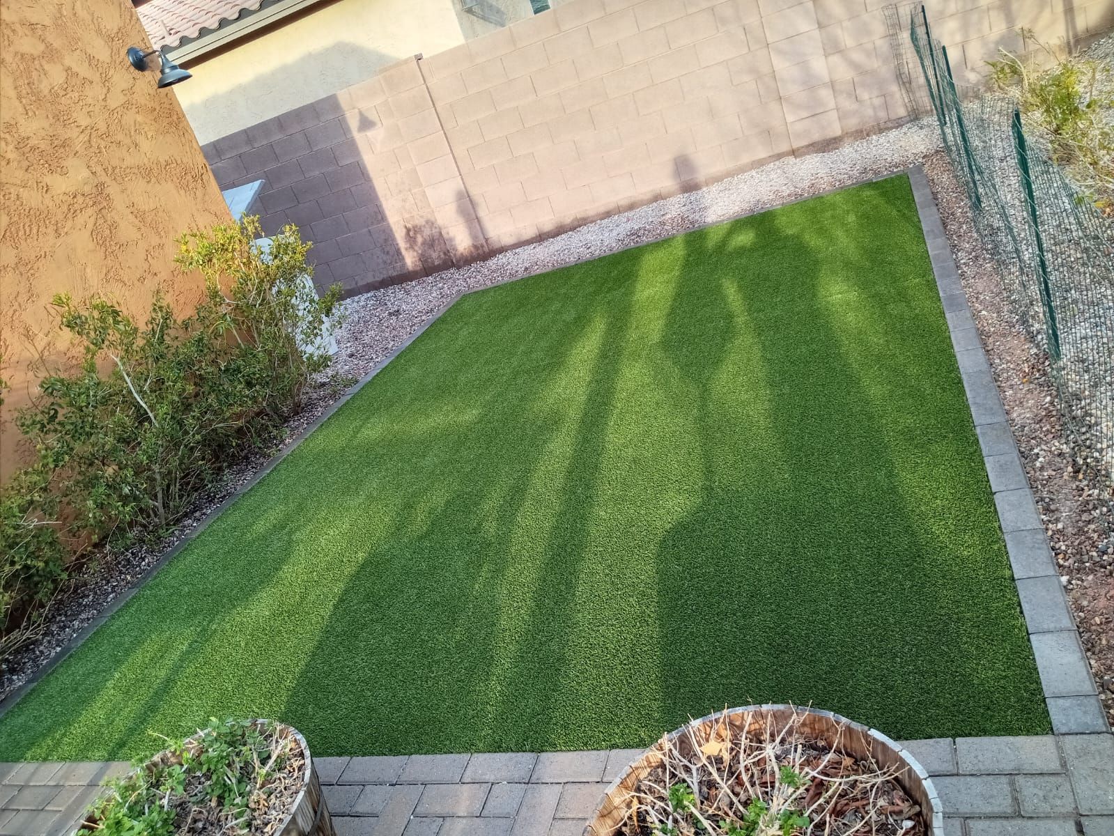 An aerial view of a backyard with a lush green lawn and potted plants.