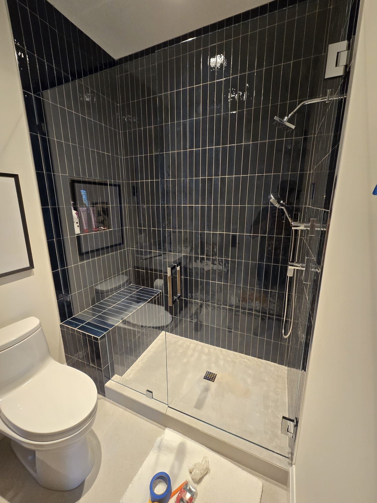 A bathroom with a toilet , sink and shower.