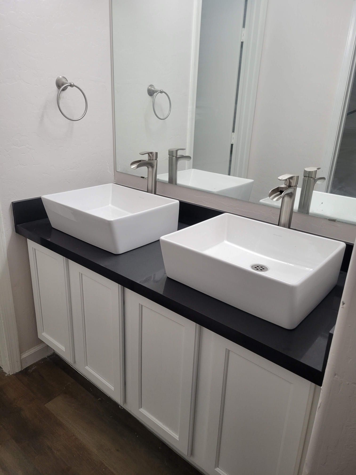 A bathroom with two sinks and a mirror.