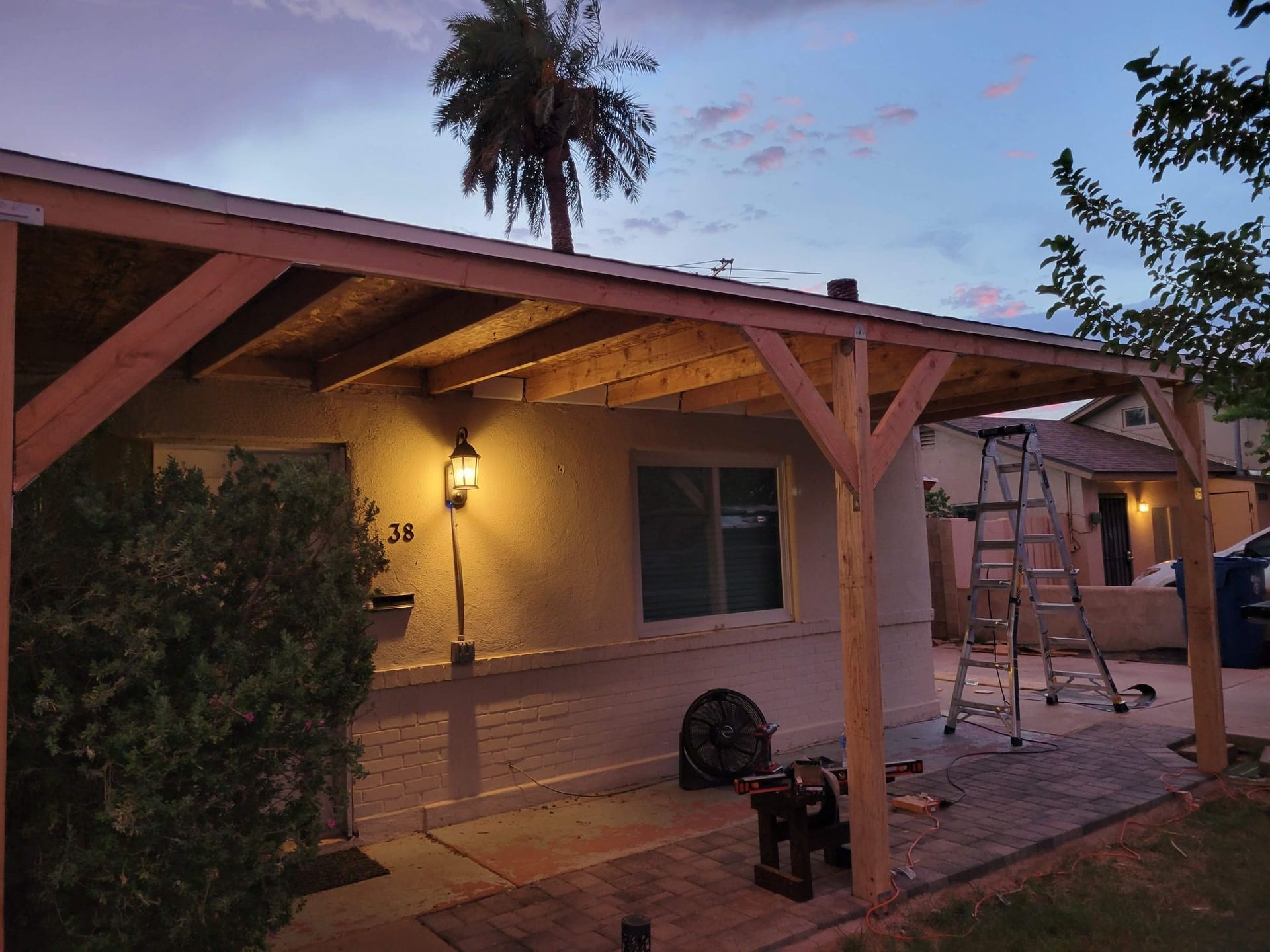 A covered porch is being built on the side of a house.