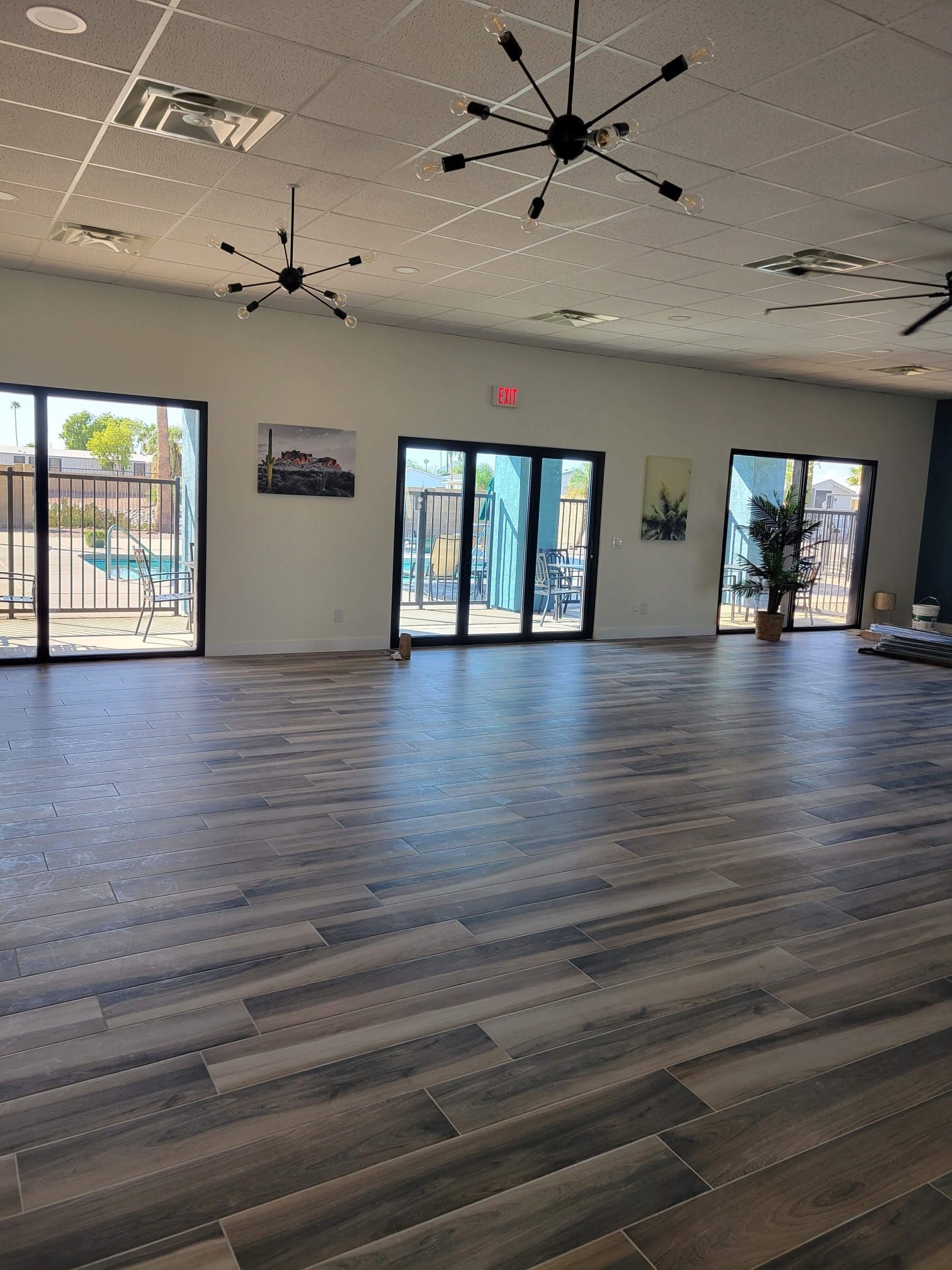 A large room with a lot of windows and a wooden floor.
