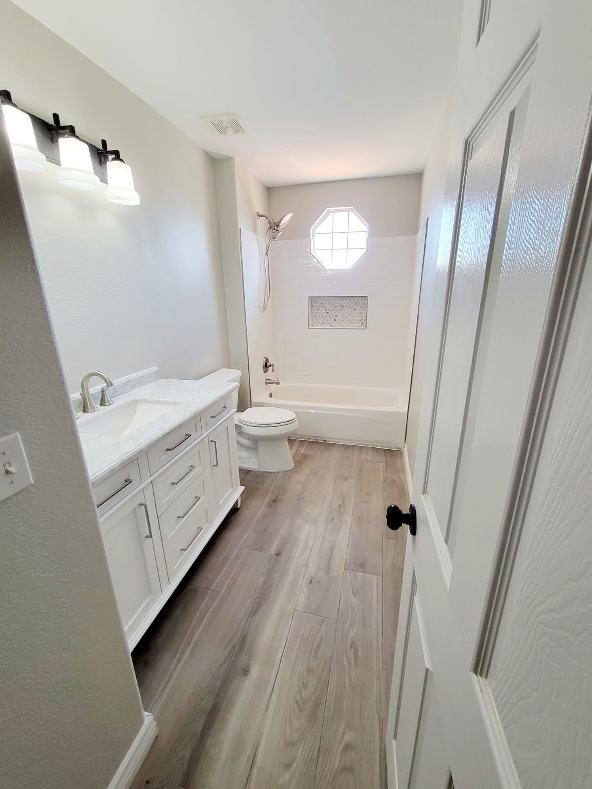 A bathroom with a sink , toilet , tub and shower.