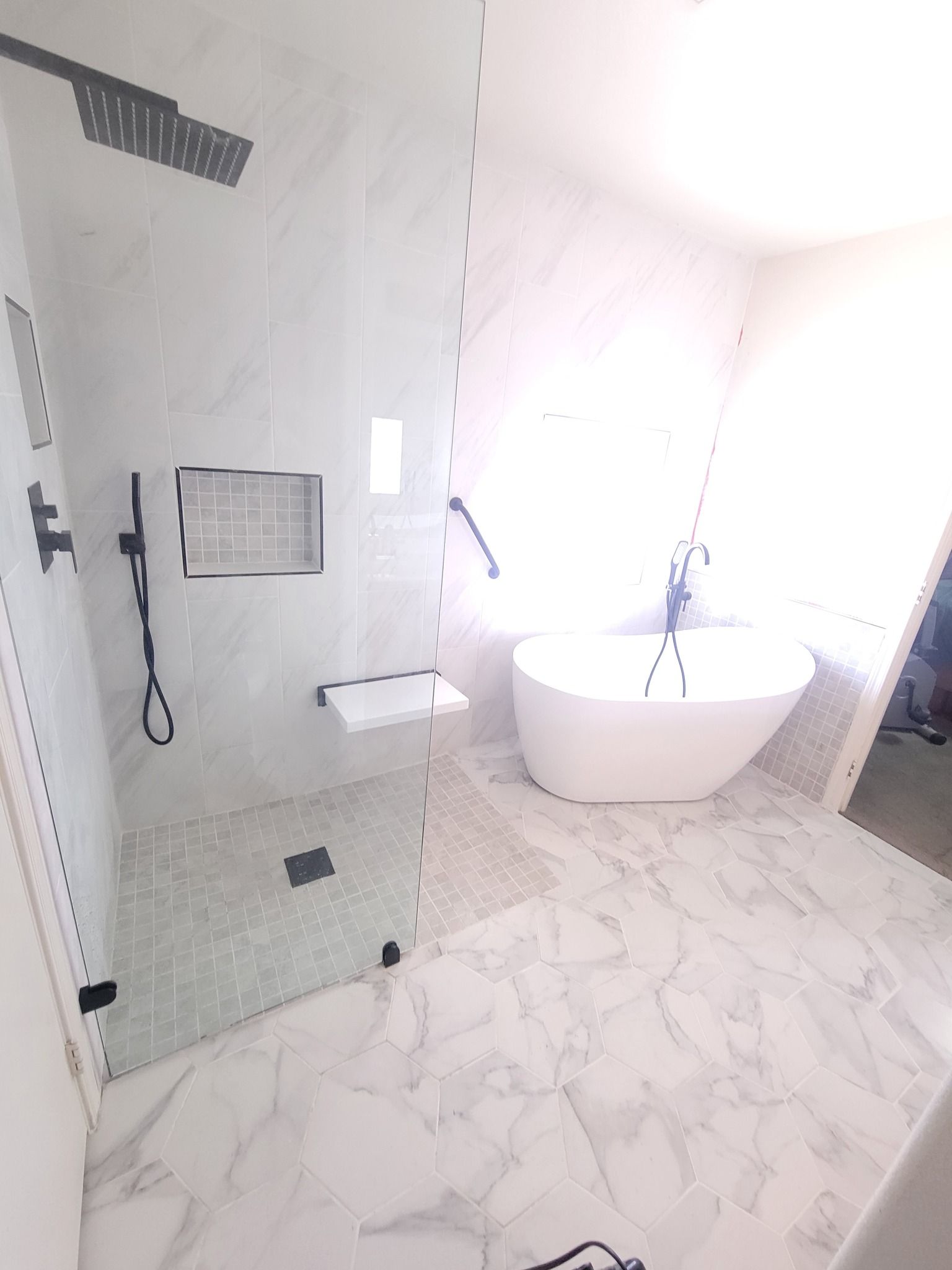 A bathroom with a tub , shower , and walk in shower.