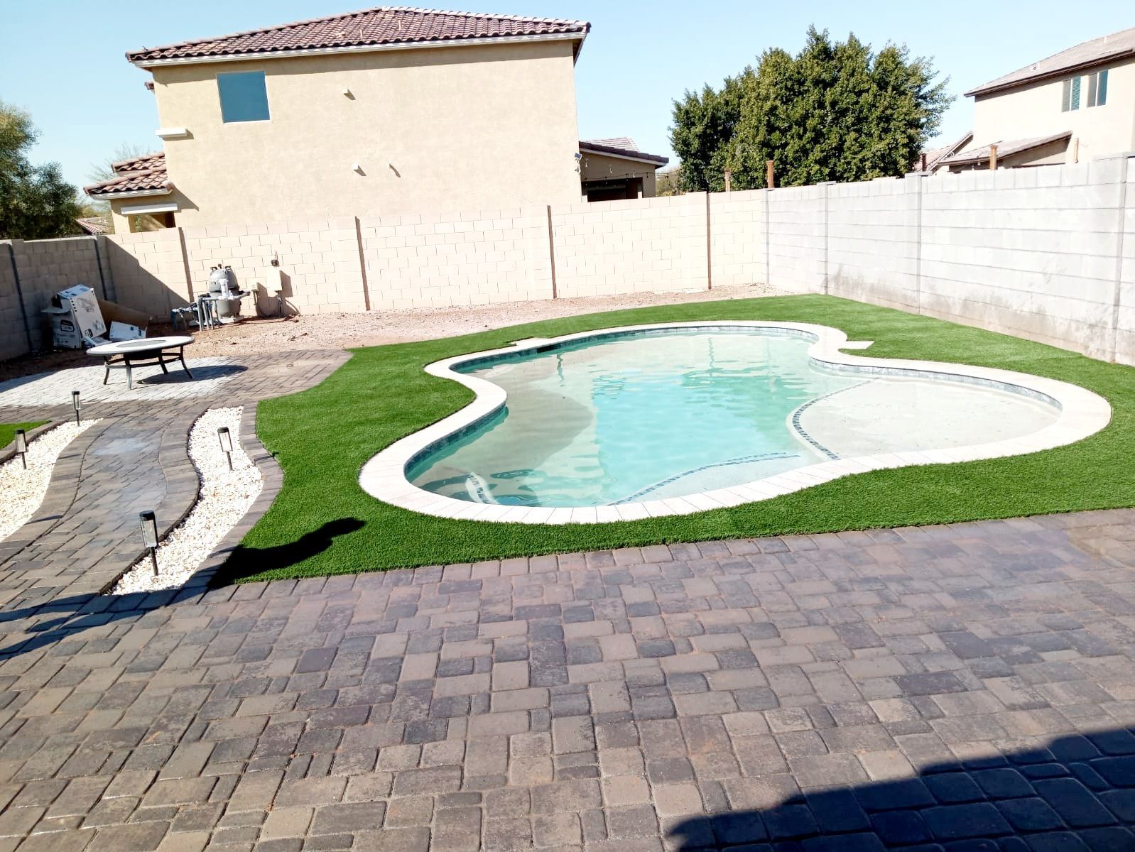 A large swimming pool in the backyard of a house