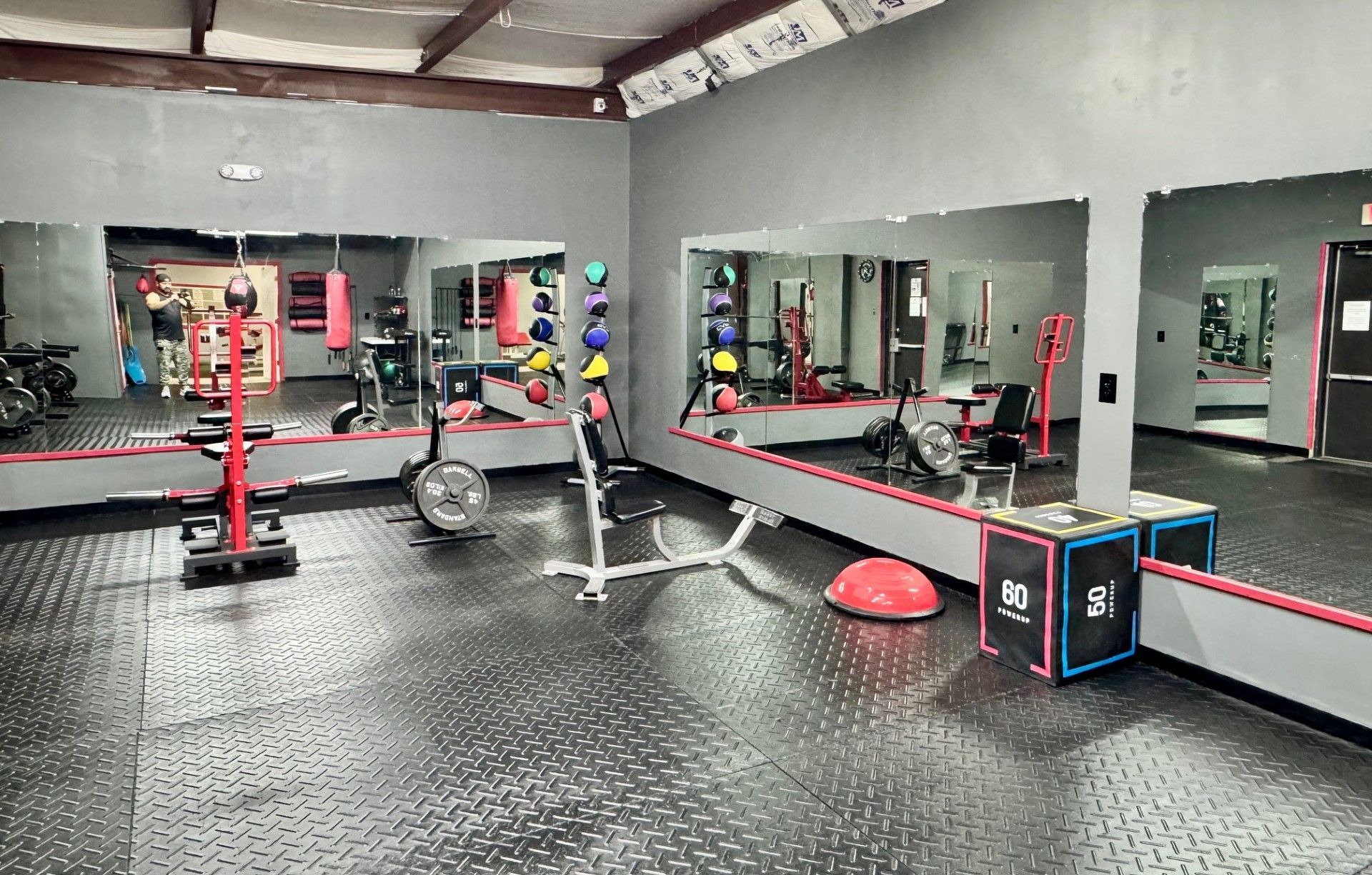 A man is holding a barbell in a gym.
