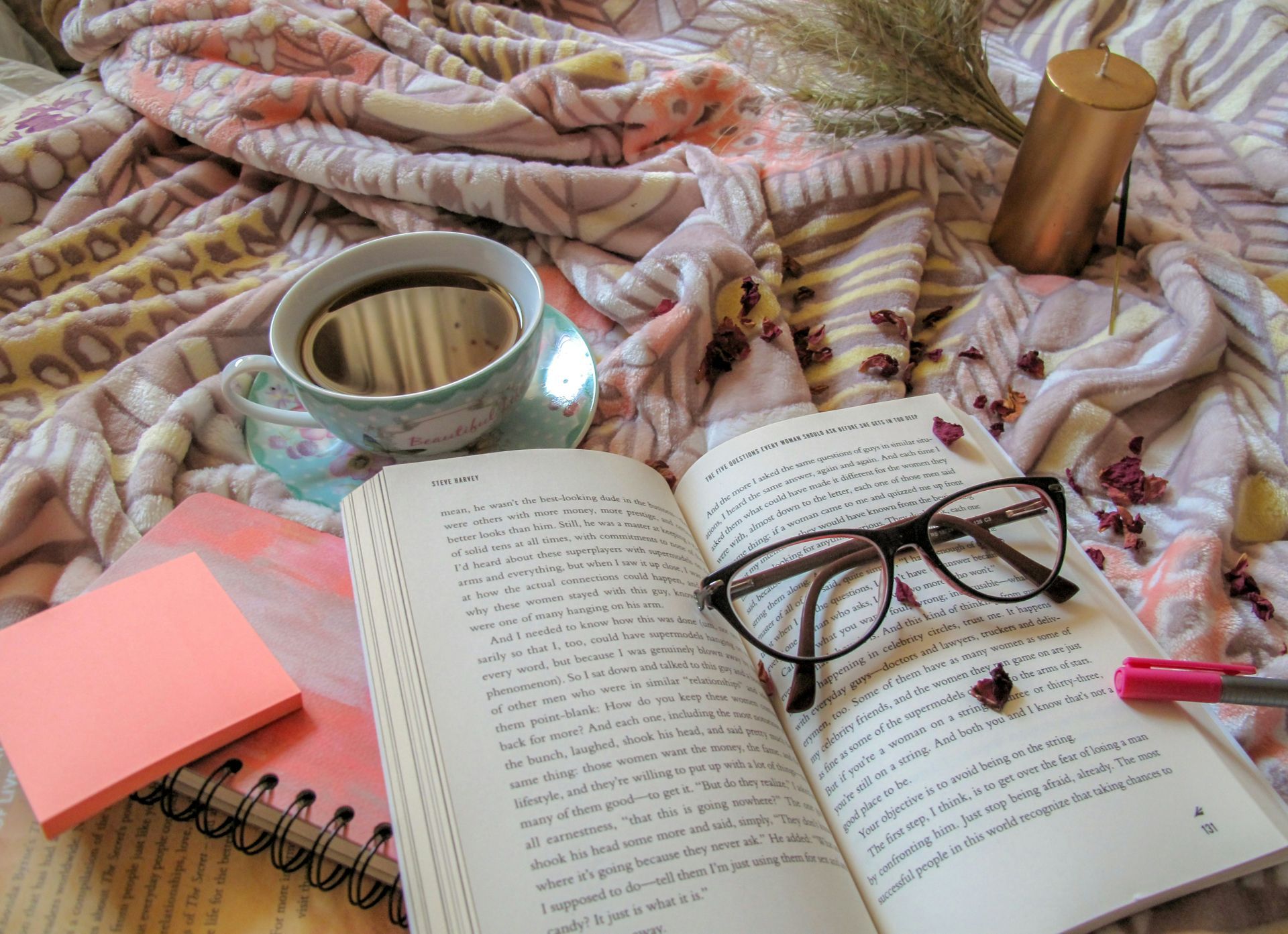 Close-up of person wearing floral apron and green shirt, gold necklace and book light visible.