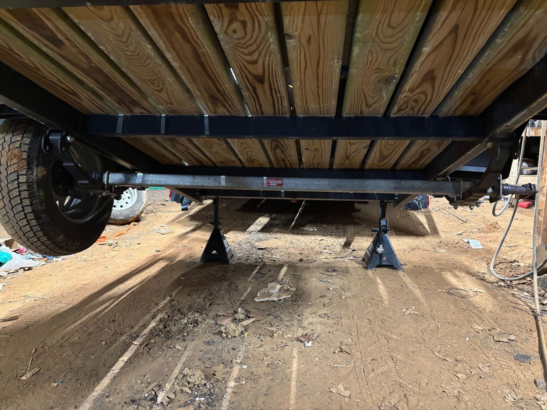 A man is working on the underside of a truck in a garage.