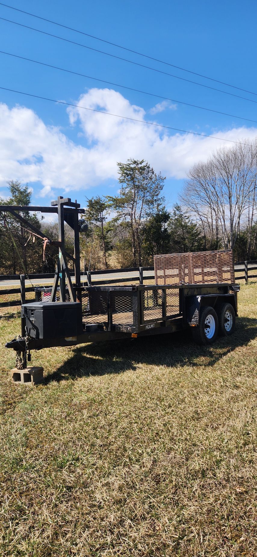 A trailer is parked in the middle of a grassy field.