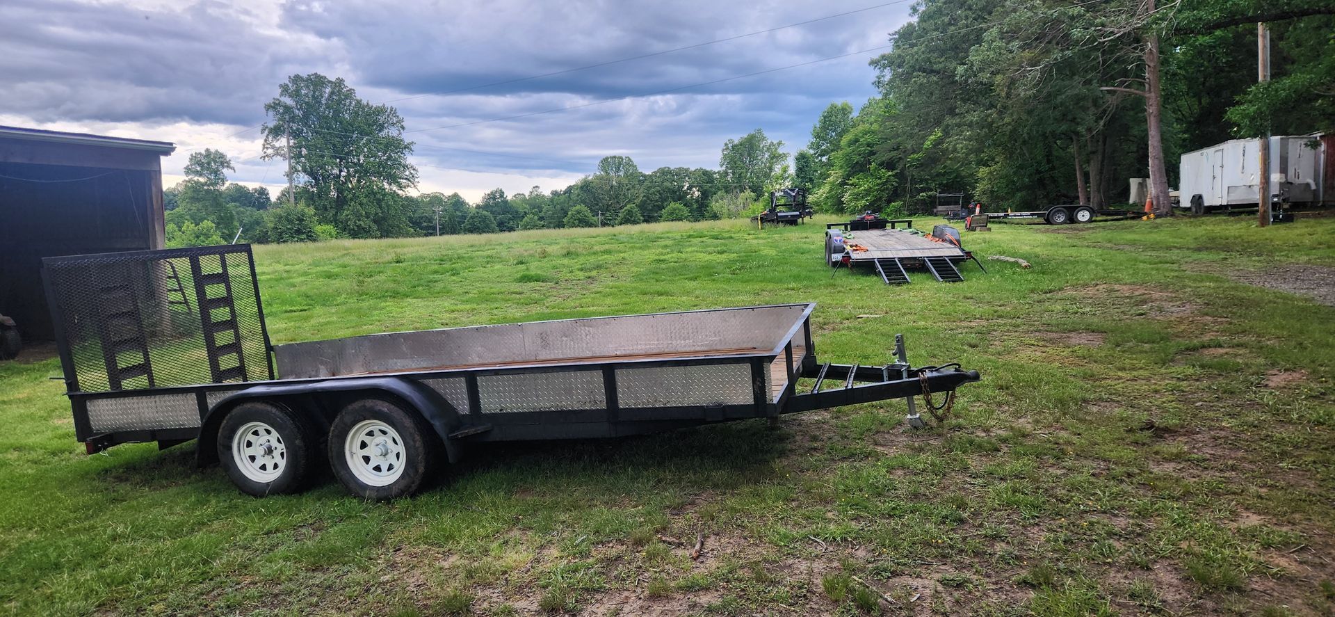 A trailer is parked in a grassy field.