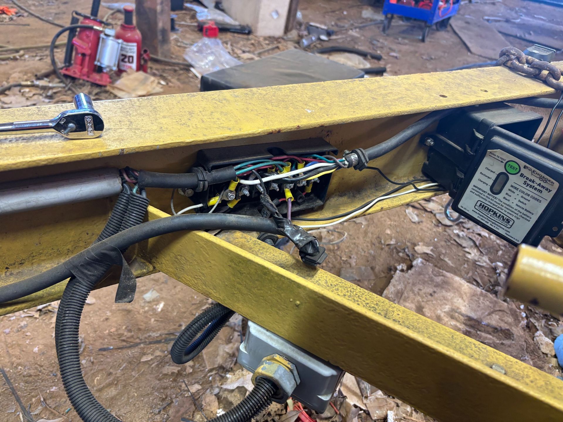 Yellow metal frame with exposed wiring, electrical box, and a control unit.