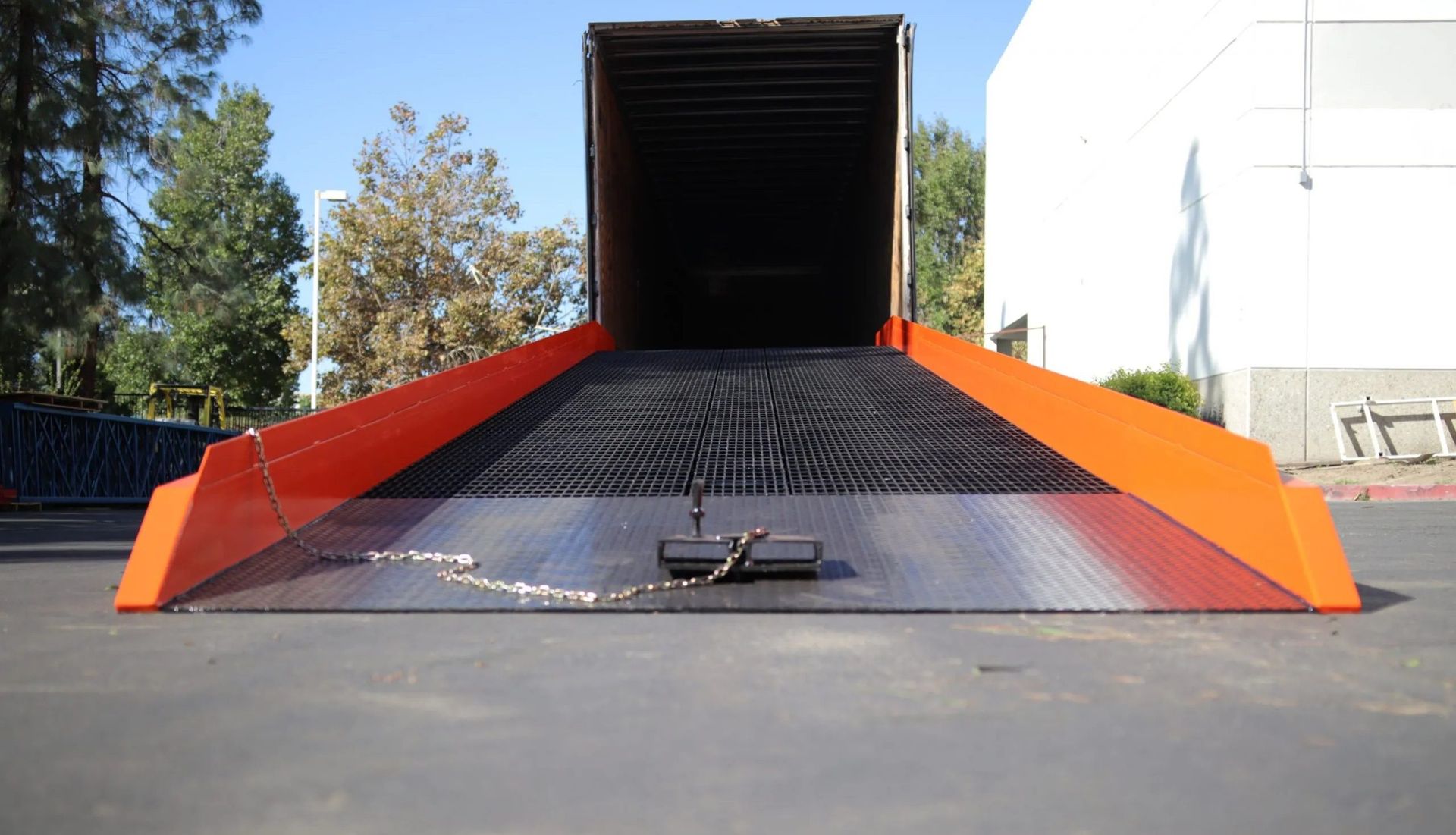 A large container is sitting on a ramp in front of a building