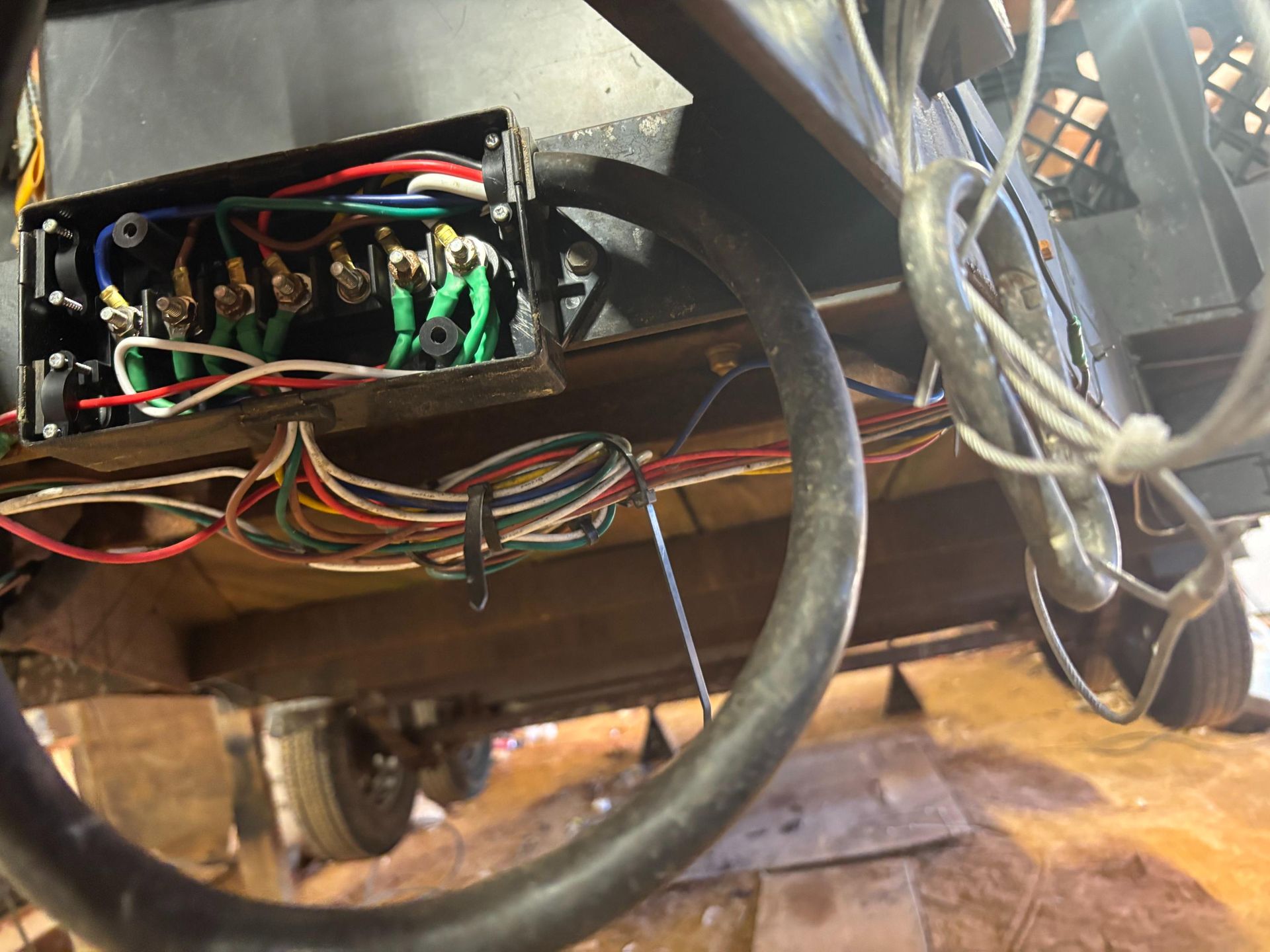 A man is working on the wiring of a car with a pair of pliers.