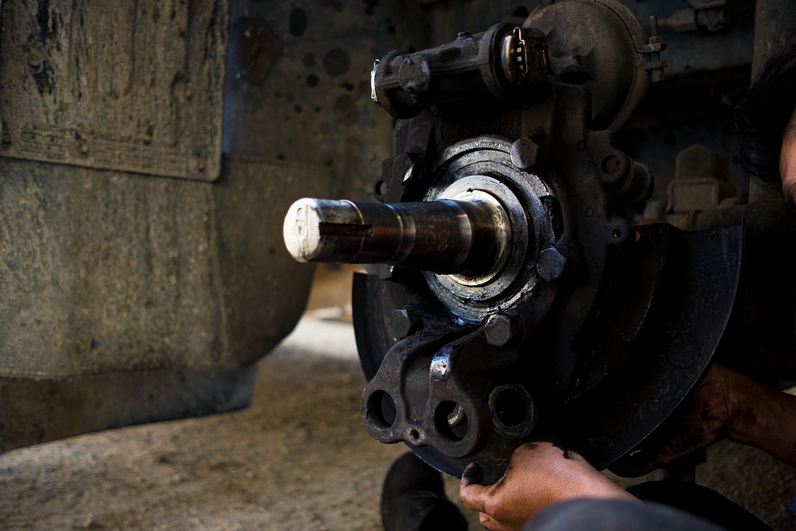 A person is working on a wheel bearing on a car.