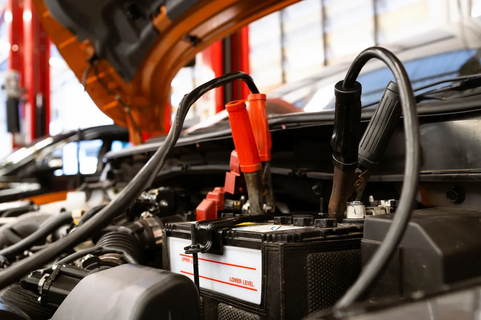 A car battery is being charged with jumper cables.