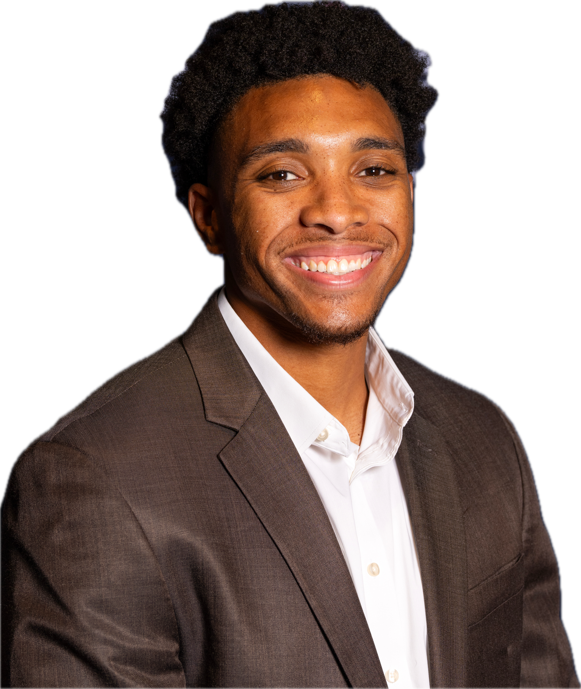 Man smiling, wearing a light blue patterned button-down shirt, against a gray background.