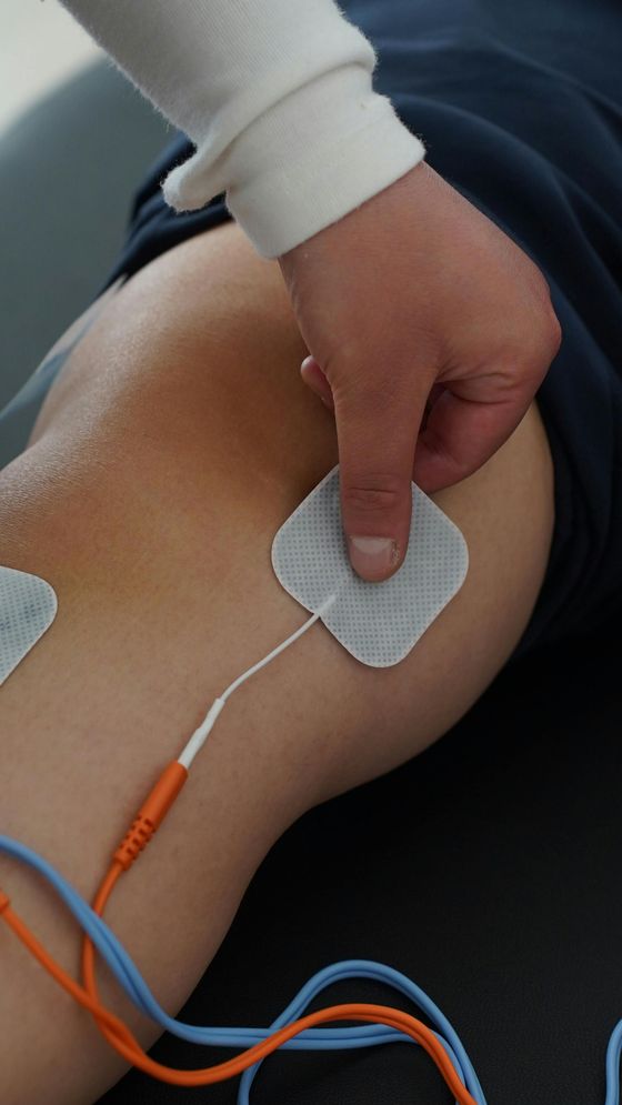 A person is getting electrodes on their knee.