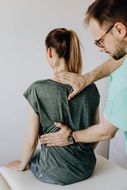 A man is giving a woman a massage on her back.