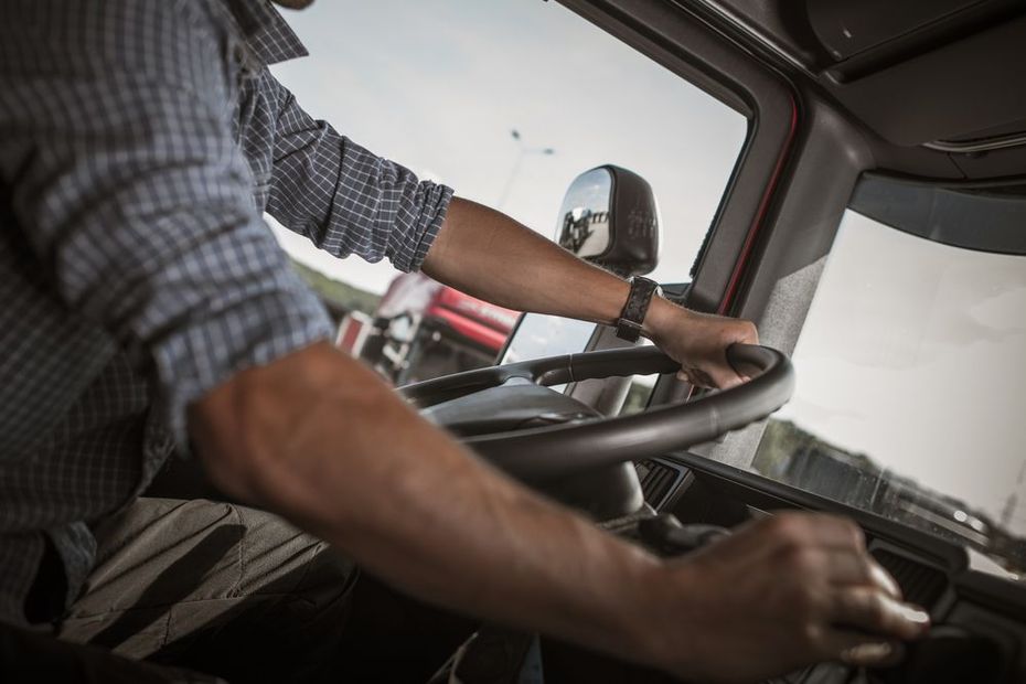 A man is driving a truck on a highway.