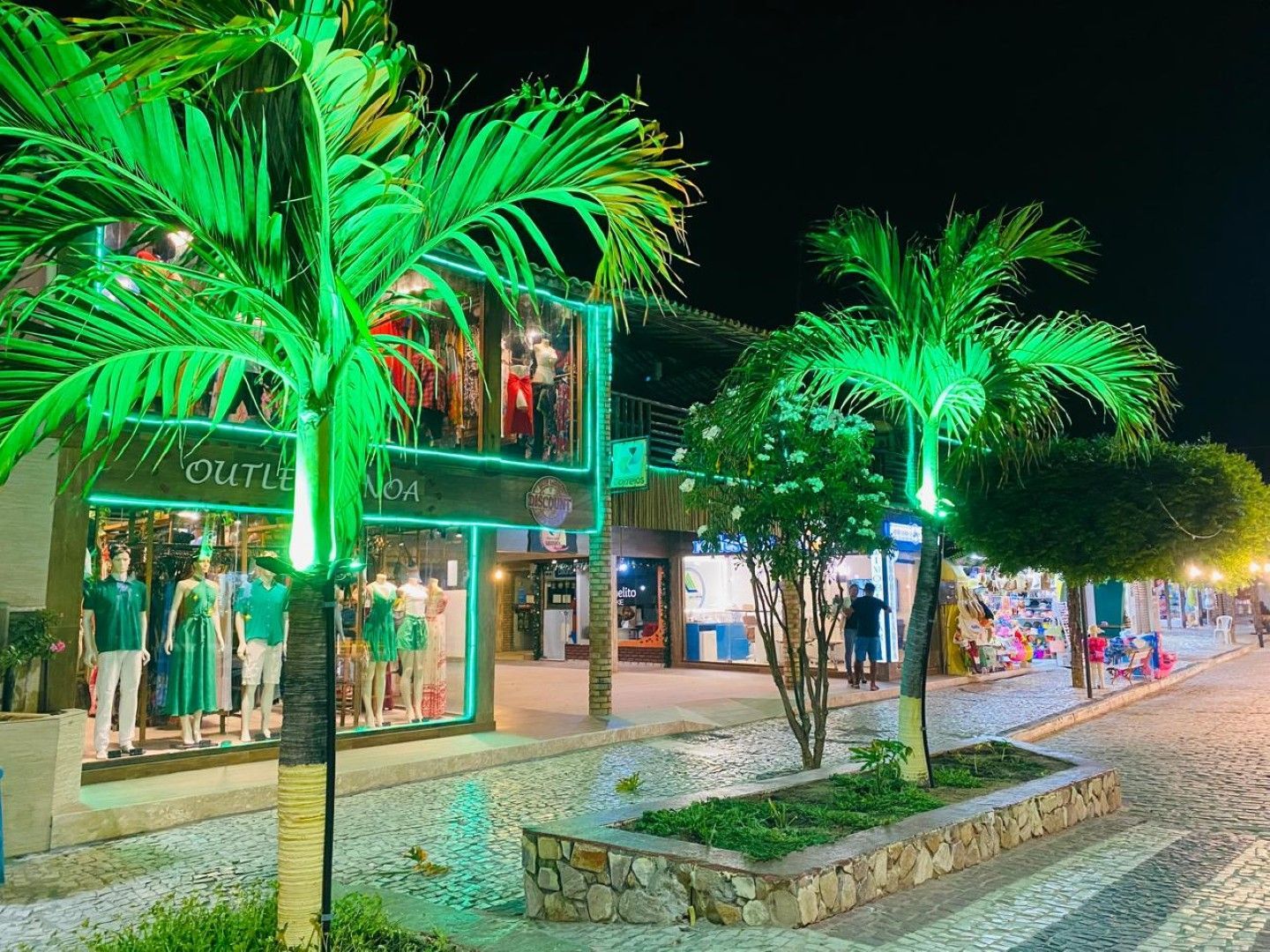 Sala de estar com paredes brancas, estantes embutidas, sofá e um pufe redondo.