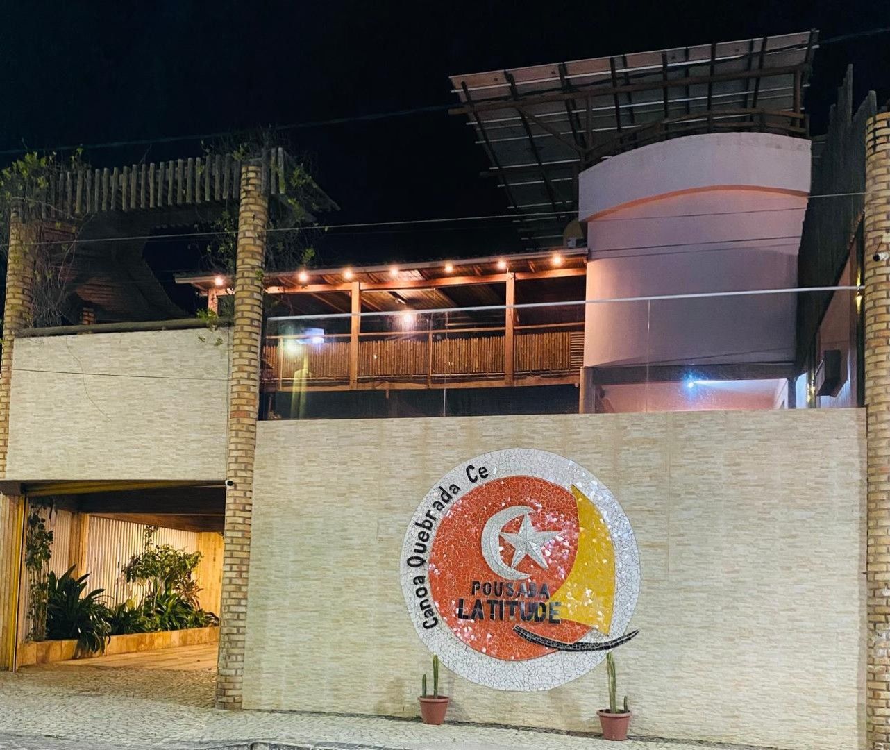 Quarto com tons neutros, detalhes em madeira e banheiro visível através de uma porta aberta.