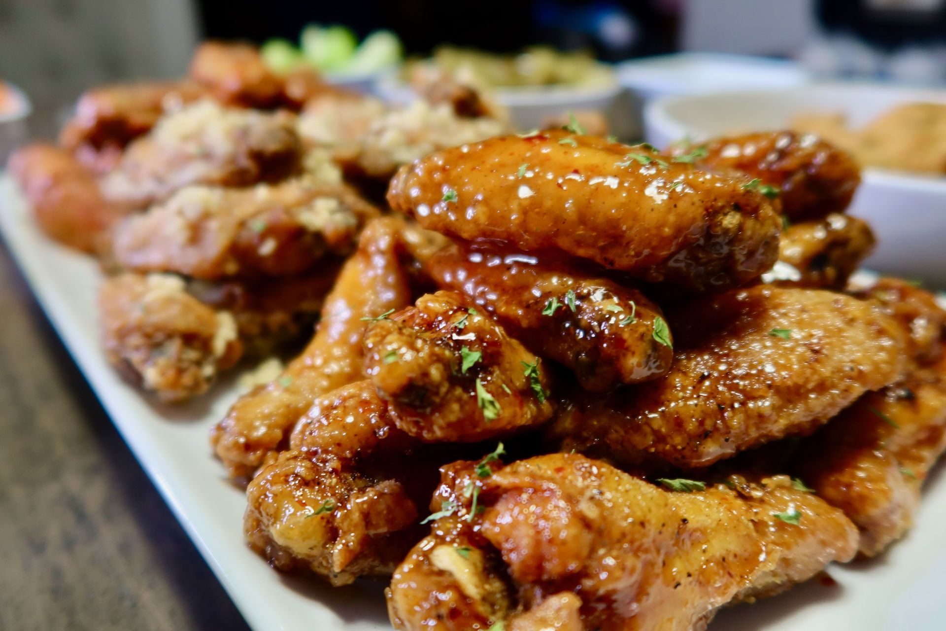 A close up of a plate of chicken wings on a table.