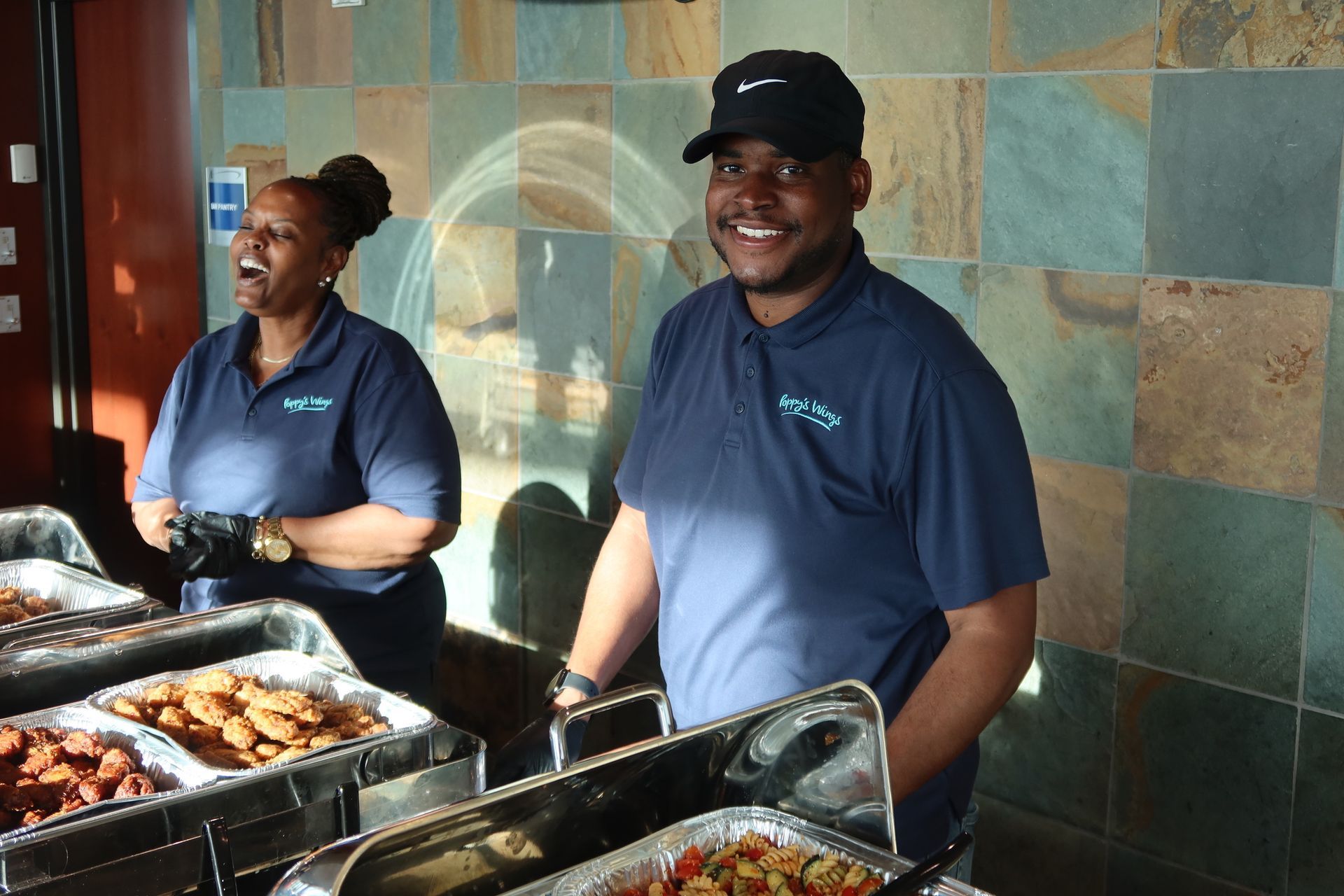 A man and a woman are standing in front of a buffet line