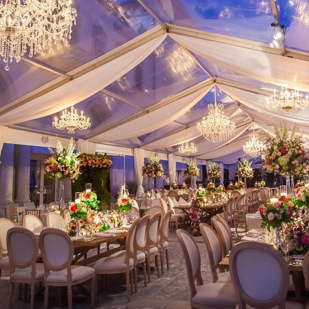 A large room with tables and chairs under a clear tent