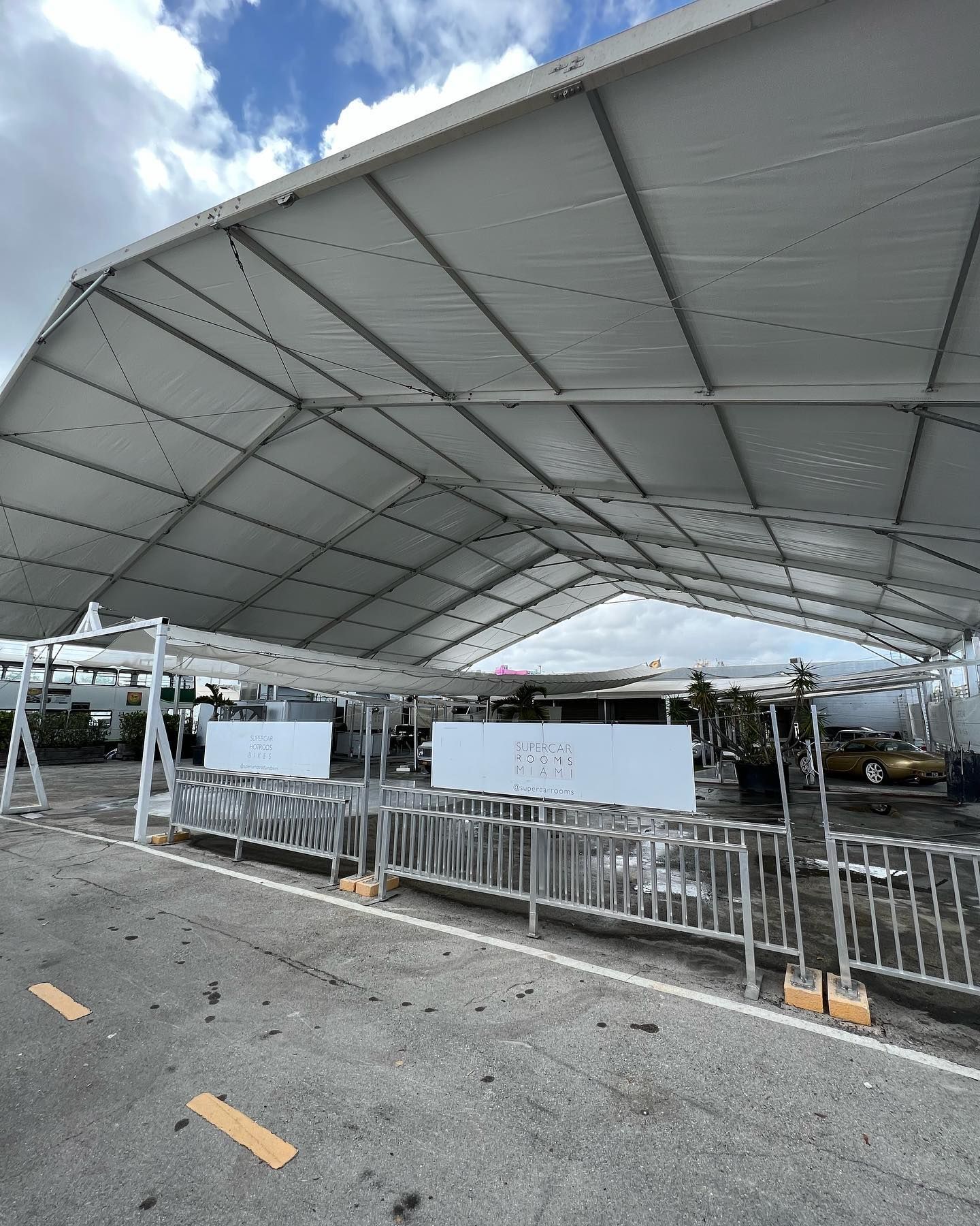 A large white tent is sitting in the middle of a parking lot.