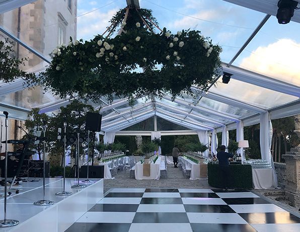 A black and white checkered dance floor under a clear tent.