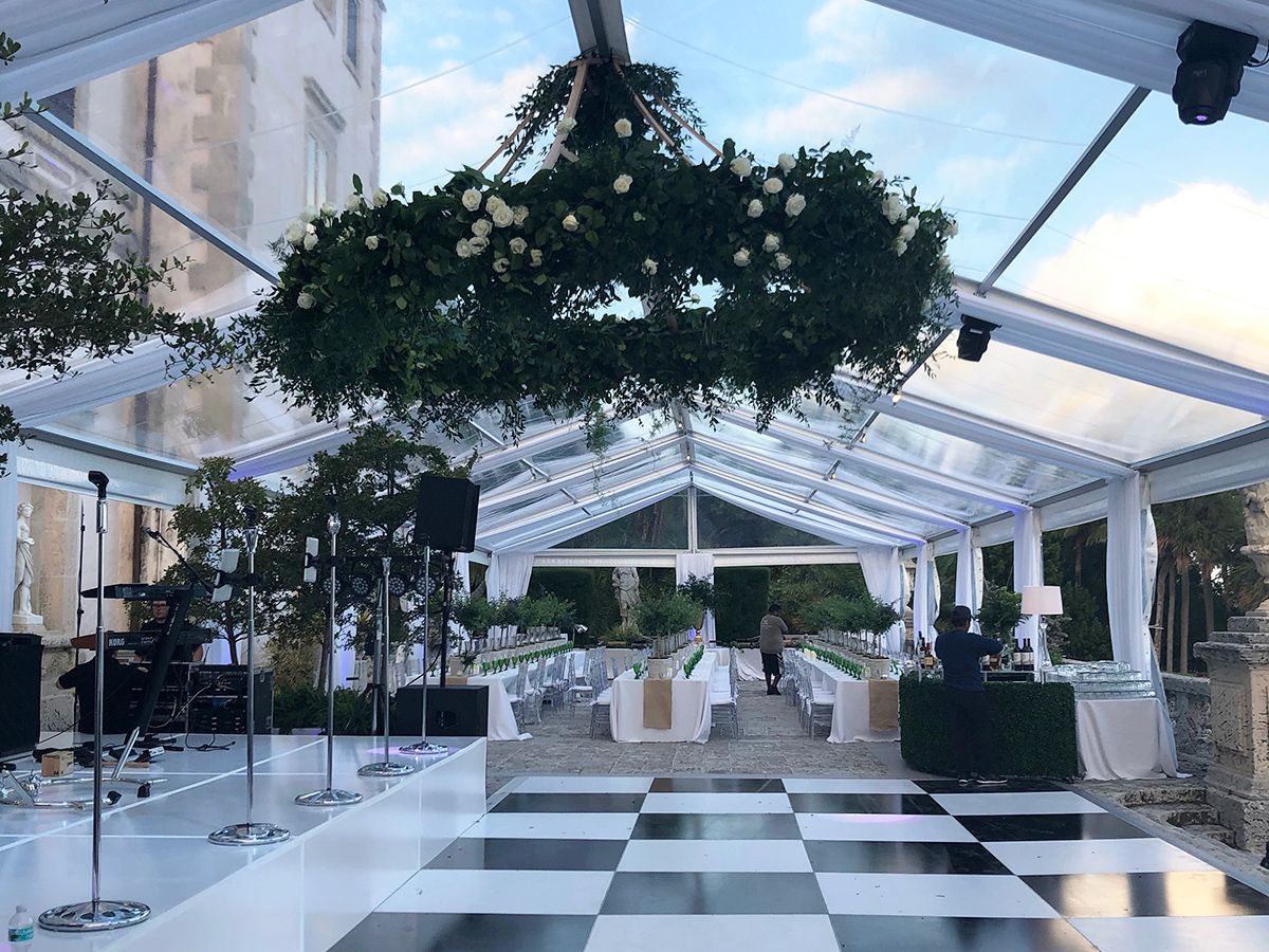 A black and white checkered dance floor under a clear tent.