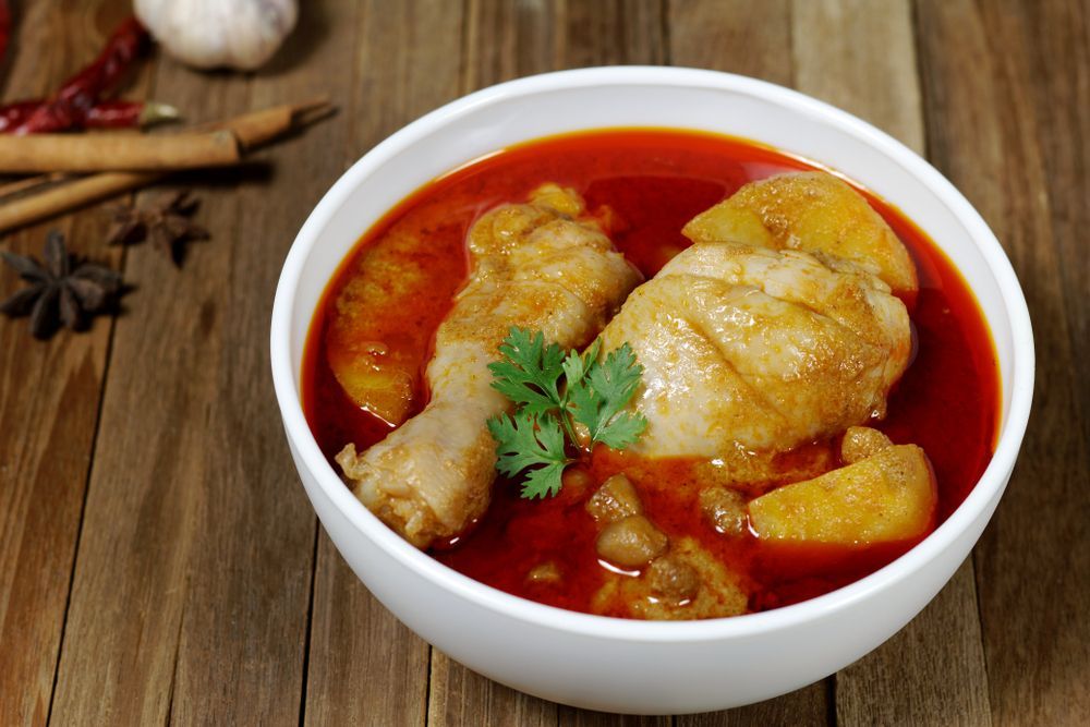 A Bowl Of Chicken Curry With Potatoes On A Wooden Table — Suhana Butcher & Grocery Shop In Millner, NT
